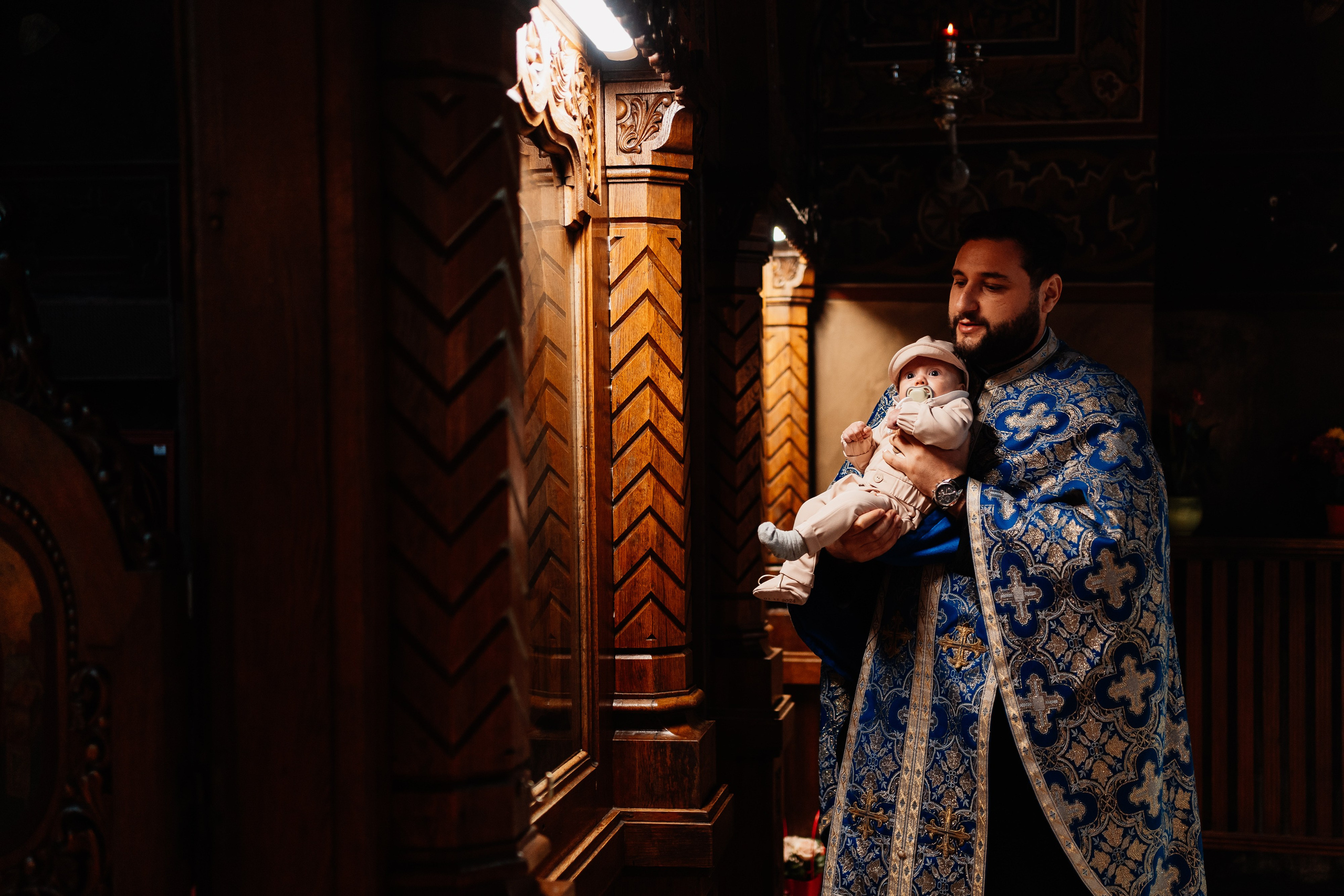 Instantaneu plin de tandrețe dintre părinți și bebeluș în ziua botezului, realizat în Craiova. Fotografie profesională de botez, capturând emoțiile autentice ale familiei într-un decor luminos și cald