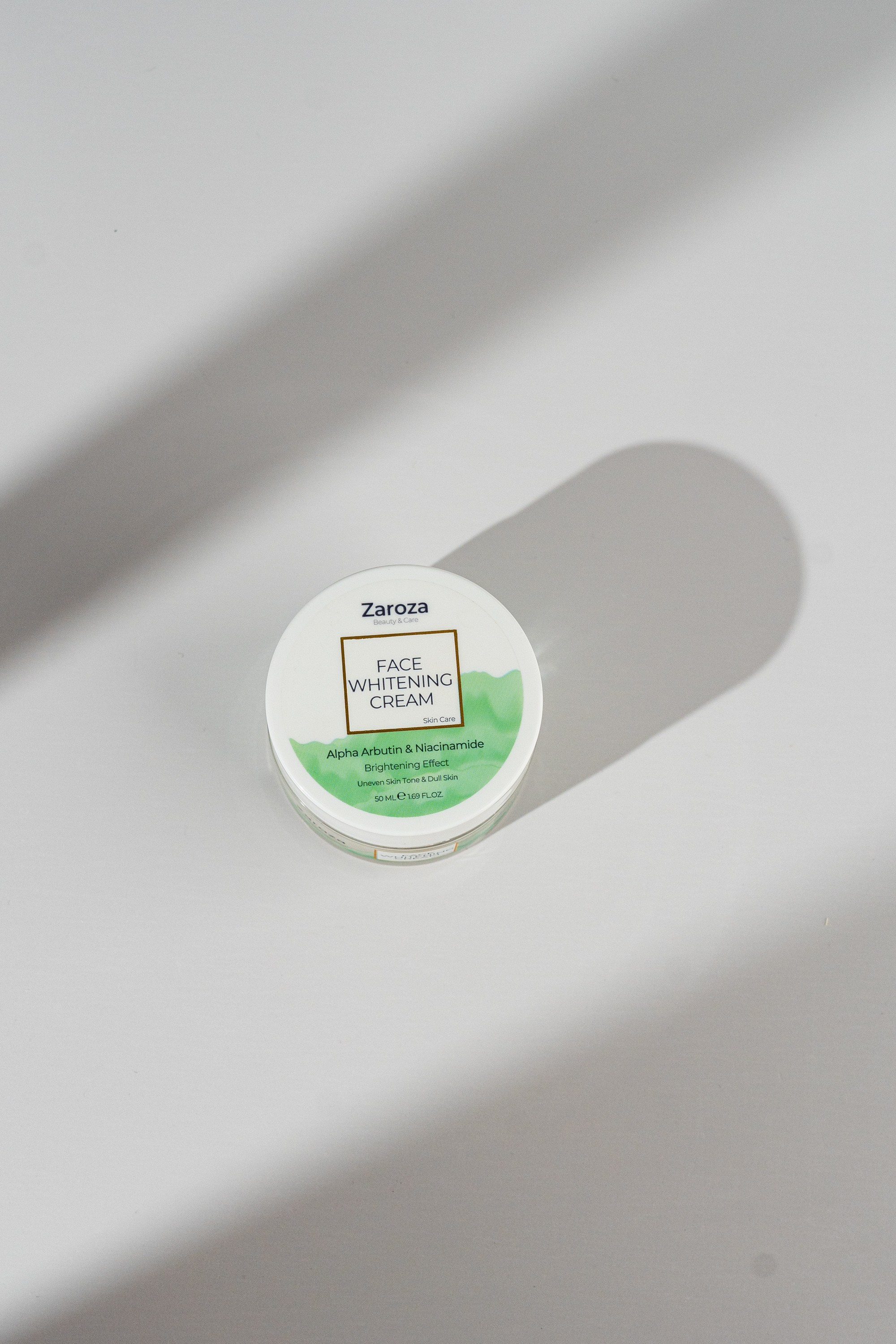 Zaroza kreminin ağ fonda konseptual kölgə işıq oyunu ilə fotosu