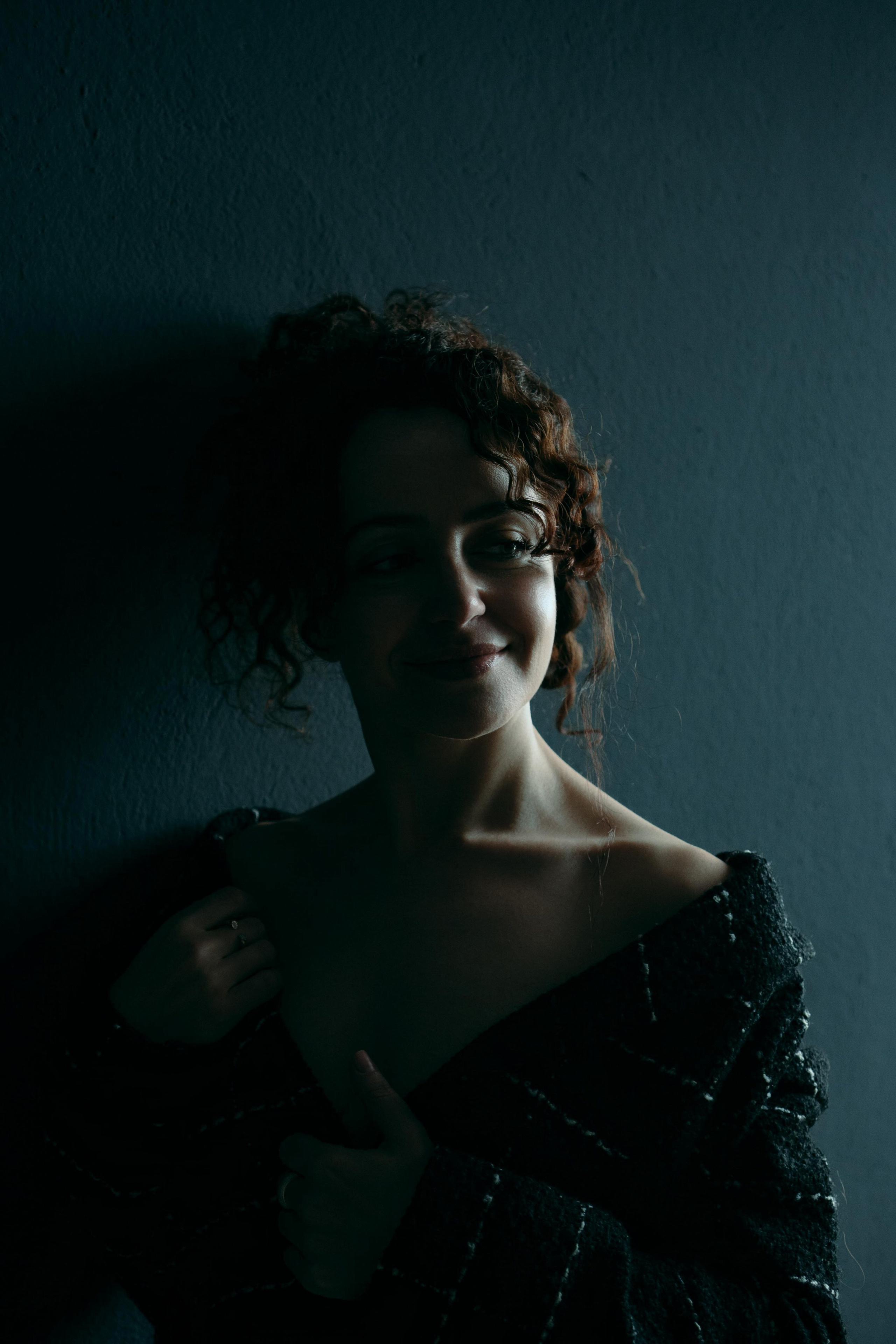 Ausdrucksstarkes Low-Key-Portrait, Frau mit nackter Schulter im Dunkeln – kreative Fotografie