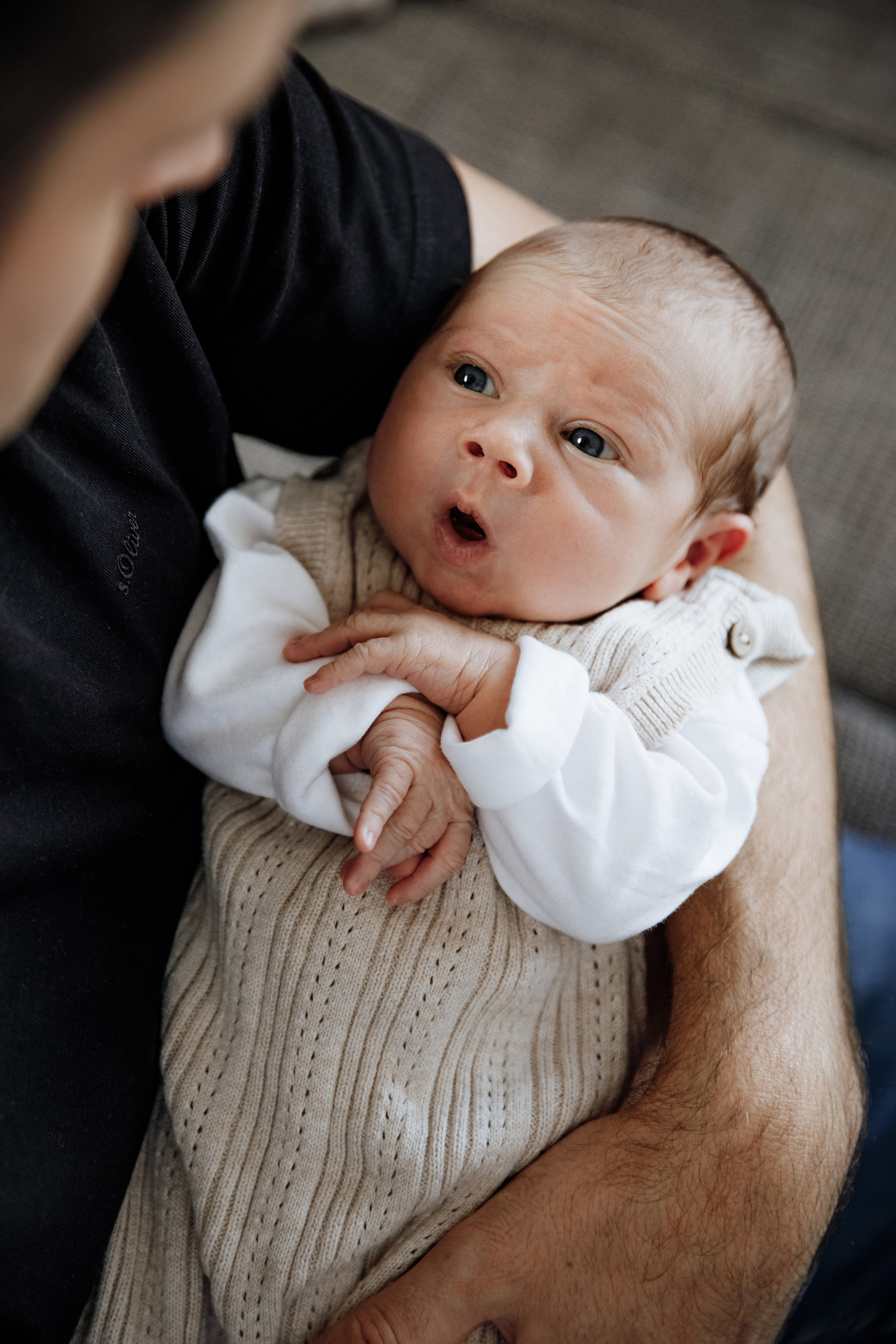 Baby schaut überrascht und neugierig zum Papa.