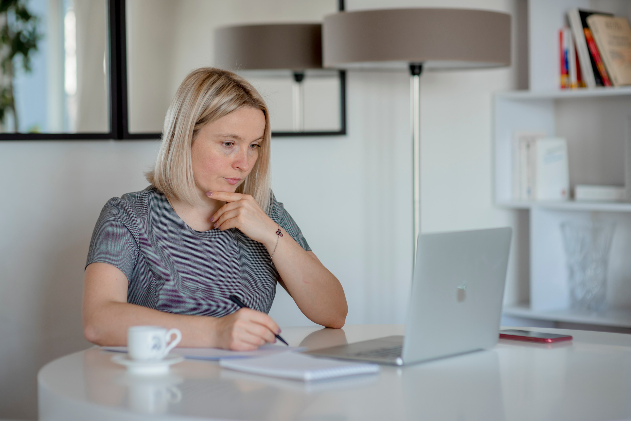 Portrait d’une femme d’affaires dans un bureau, travaillant sur un ordinateur portable.