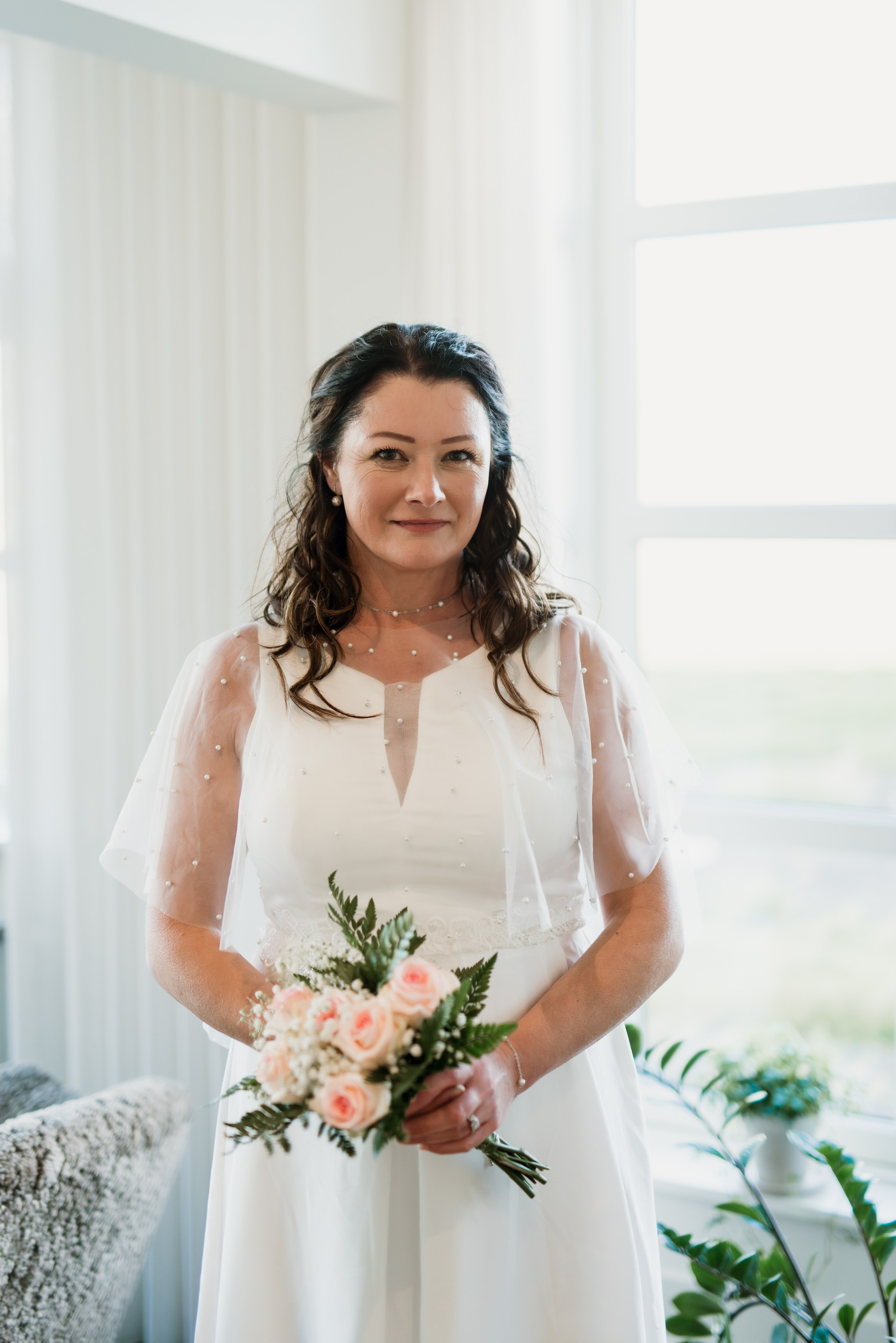 Bride in her wedding dress walking through the rustic halls of Hotel Búðir, the soft lighting creating a dreamy atmosphere.