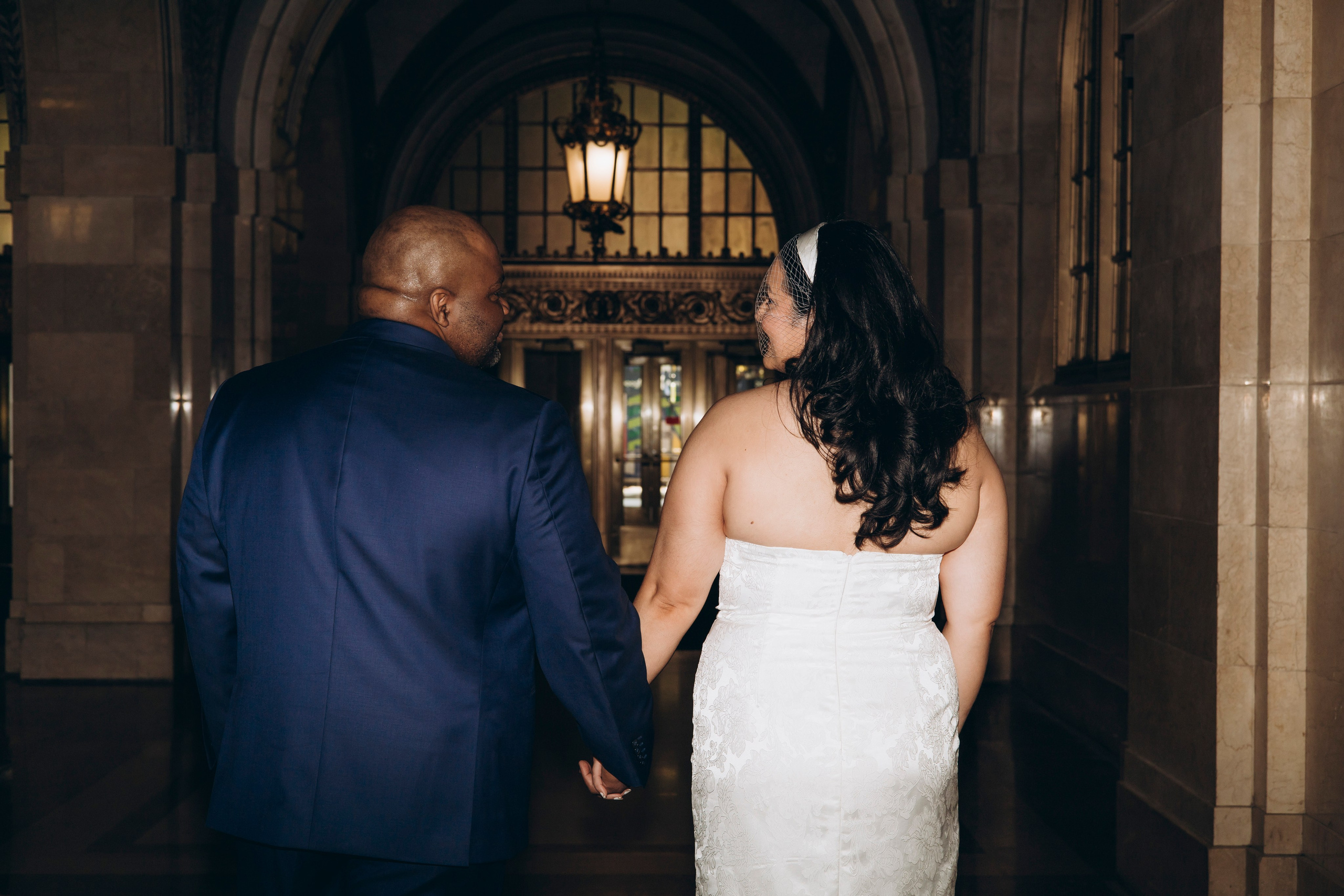 Bride and groom walking hand in hand inside Chicago City Hall