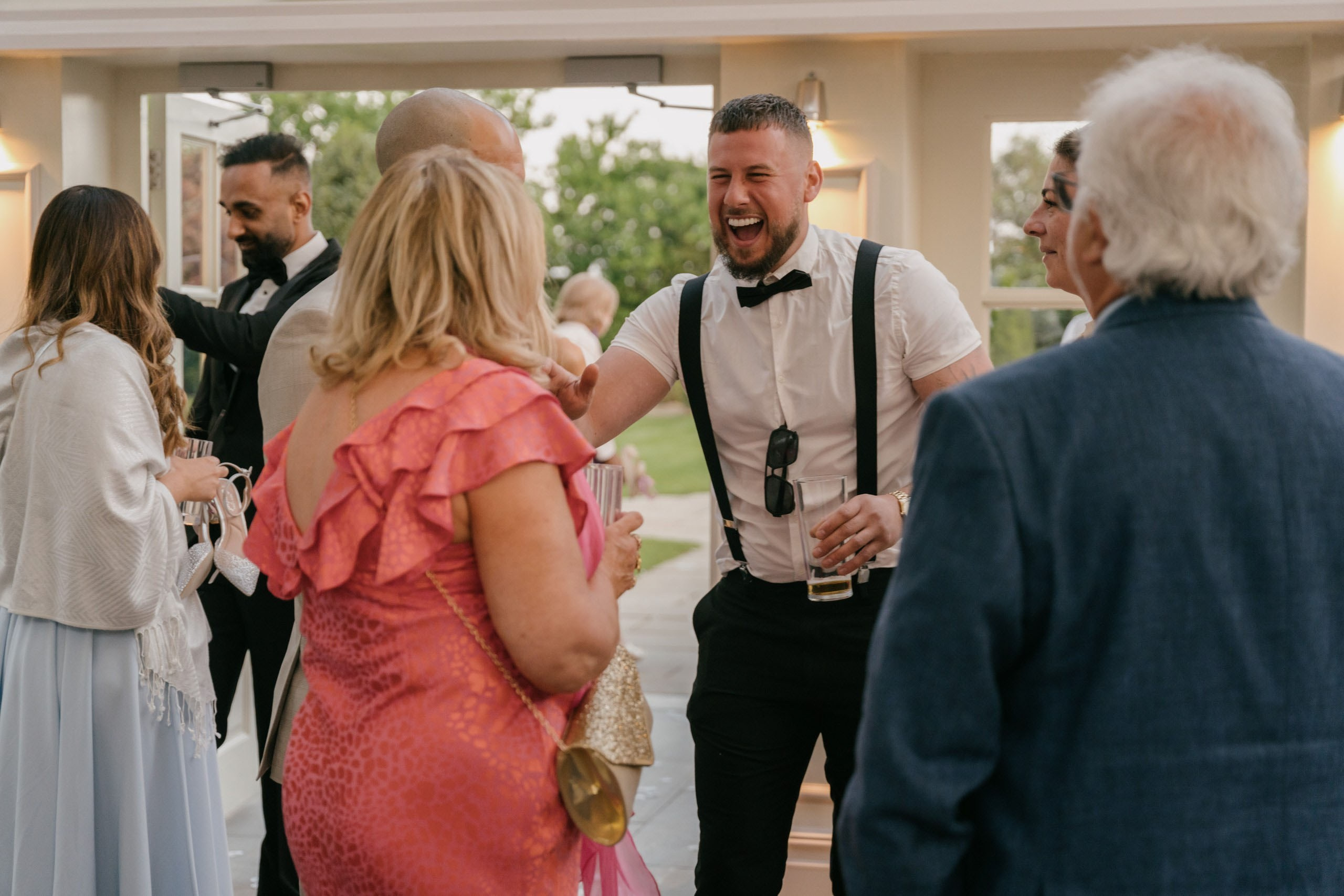 Guests socialising drinks outdoor wedding reception Essex