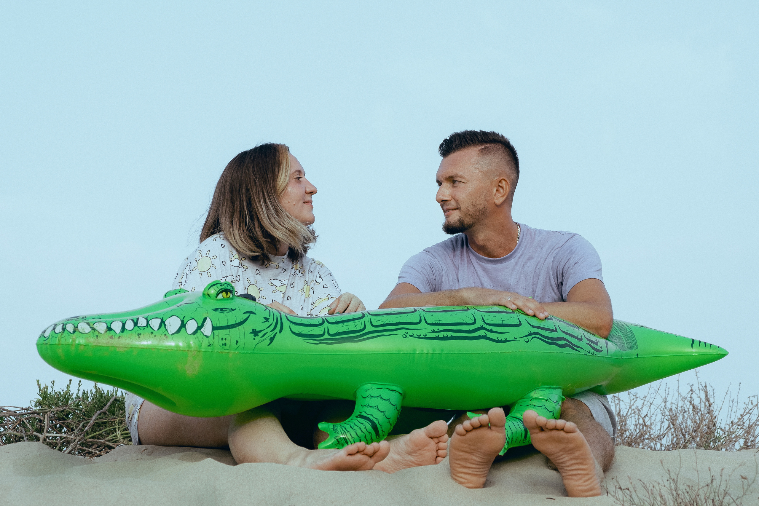 Crazy love story on the beach with an inflatable crocodile