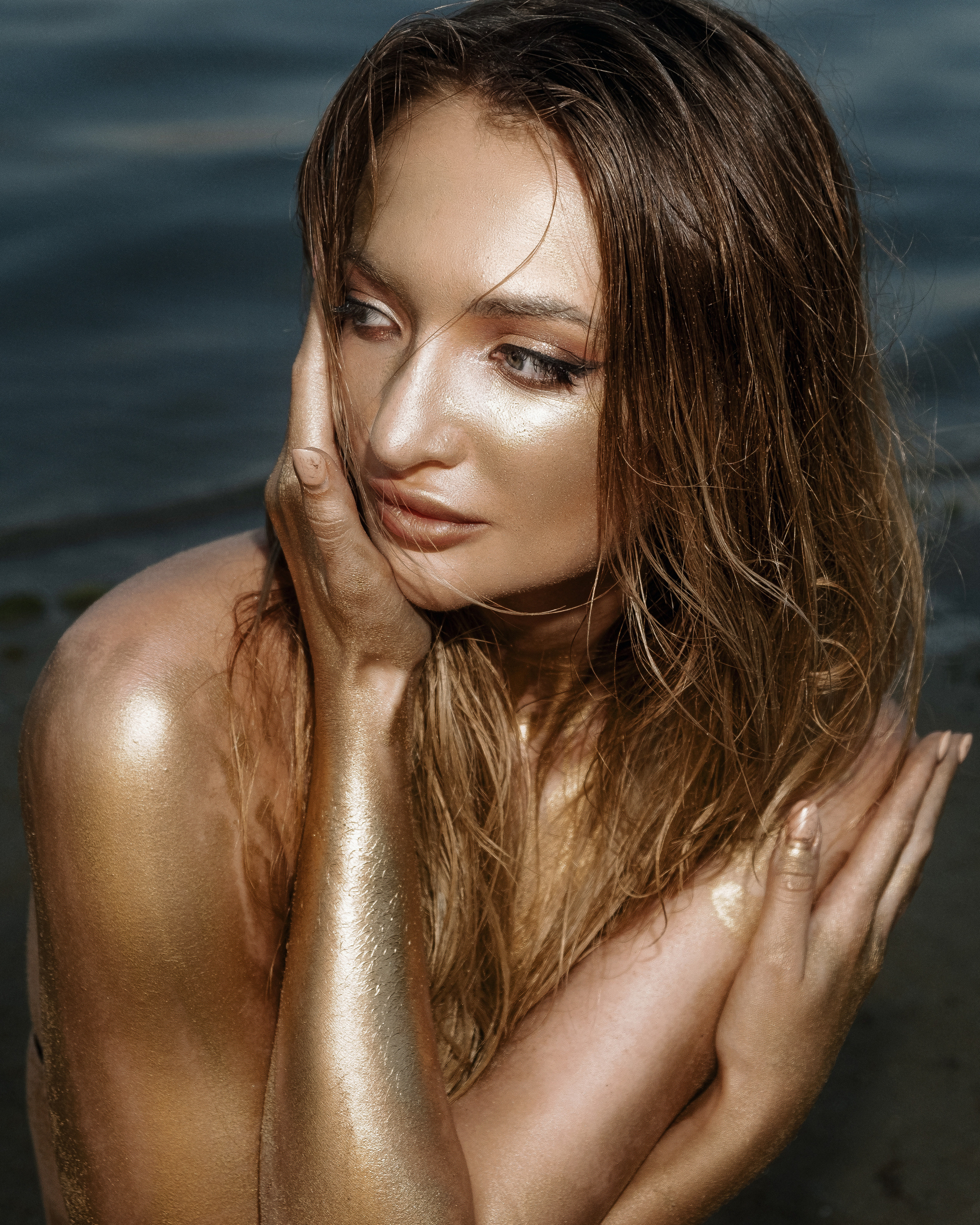 Фотосессия девушки в золотой краске на пляже