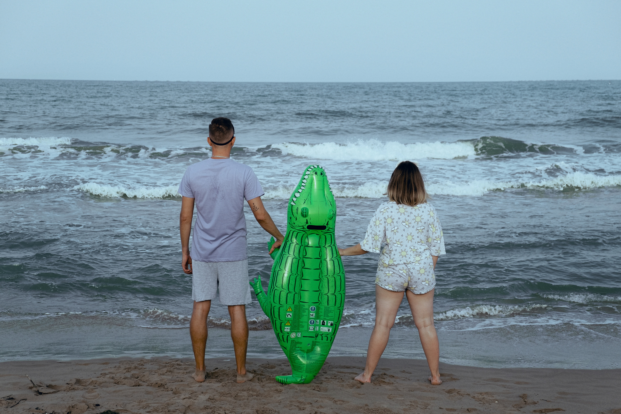 Crazy love story on the beach with an inflatable crocodile