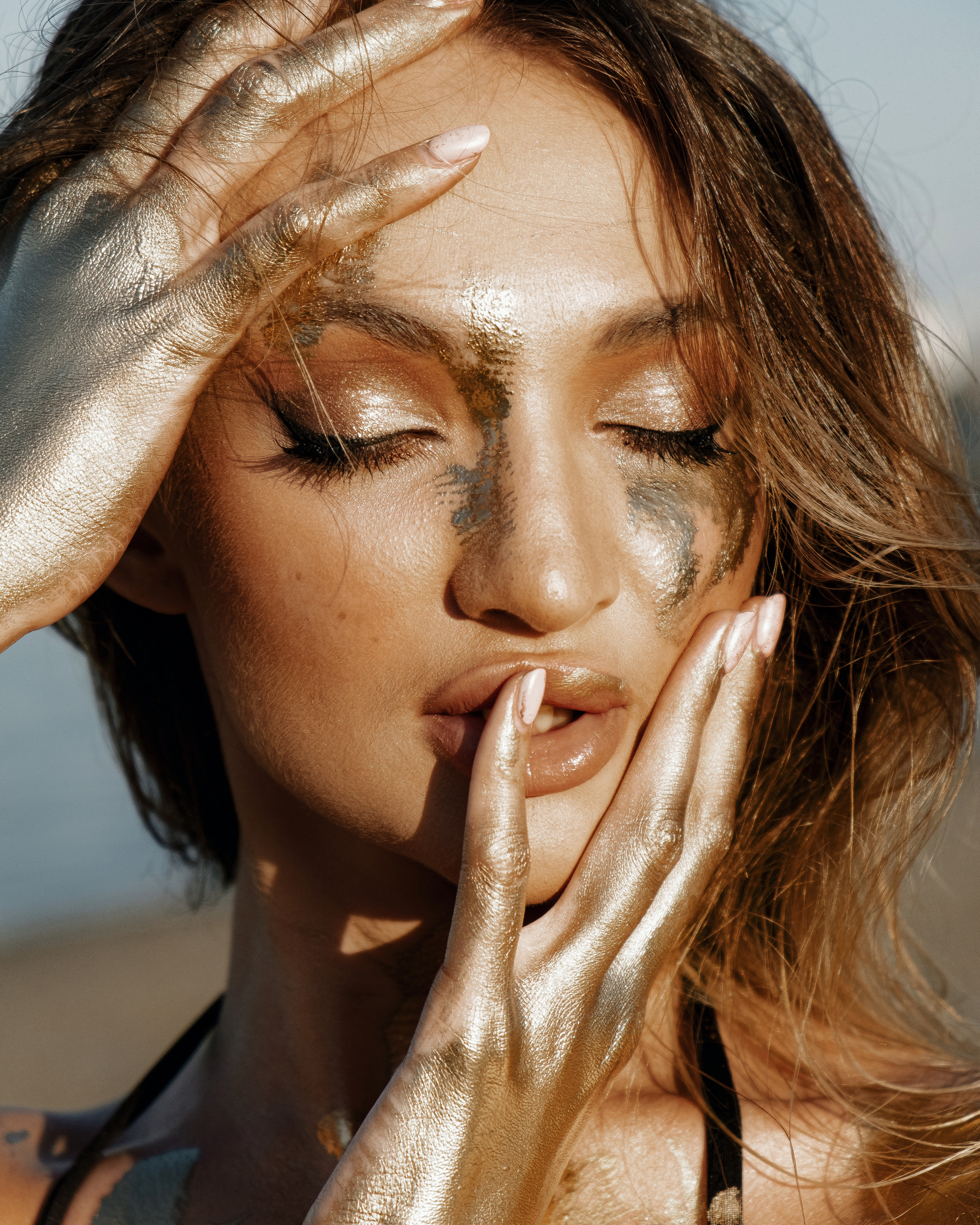 Фотосессия девушки в золотой краске на пляже