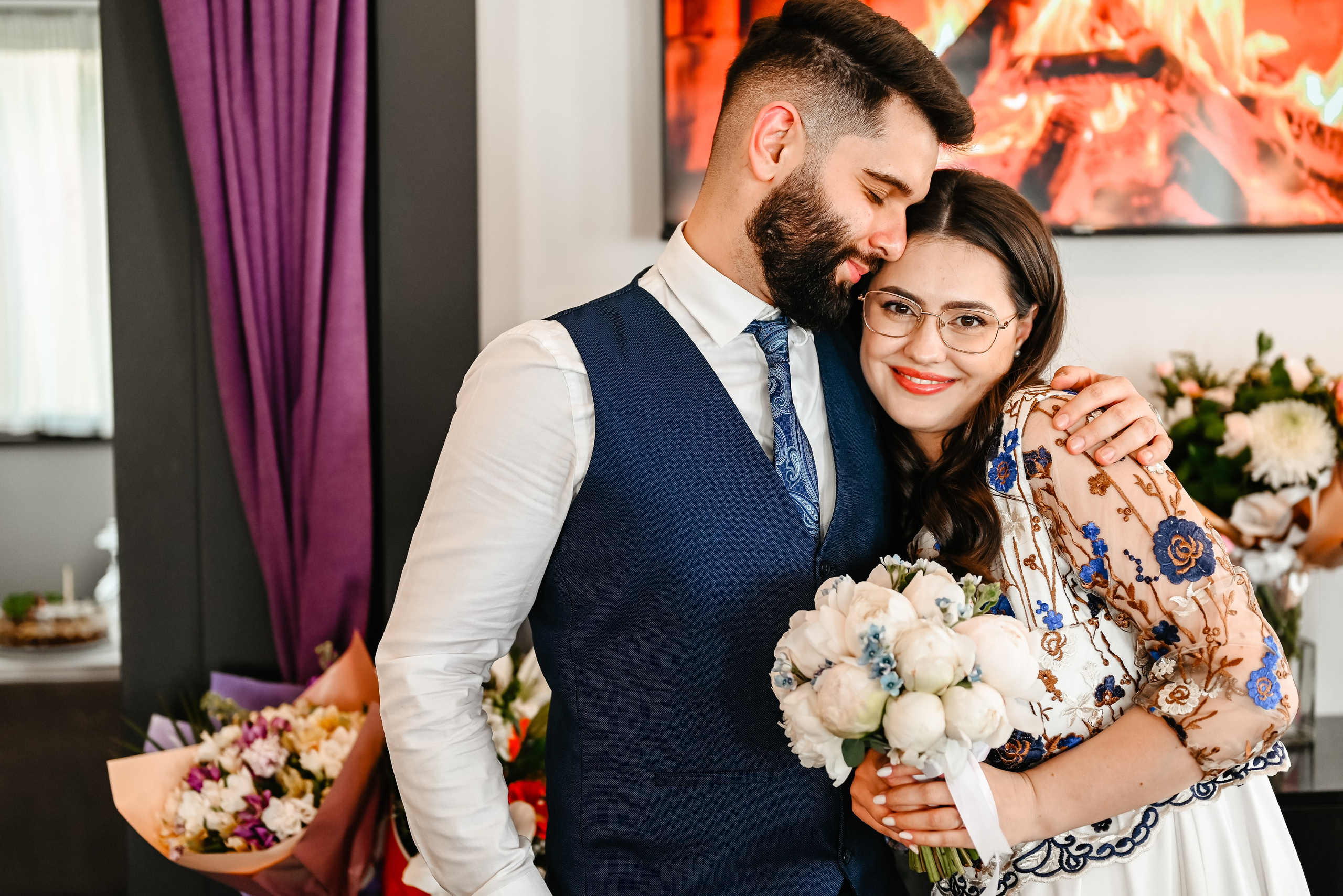 Cuplu proaspăt căsătorit zâmbind emoționat în lumina naturală, în cadrul restaurantului decorat festiv – Foto Ana Maria Drăgan.