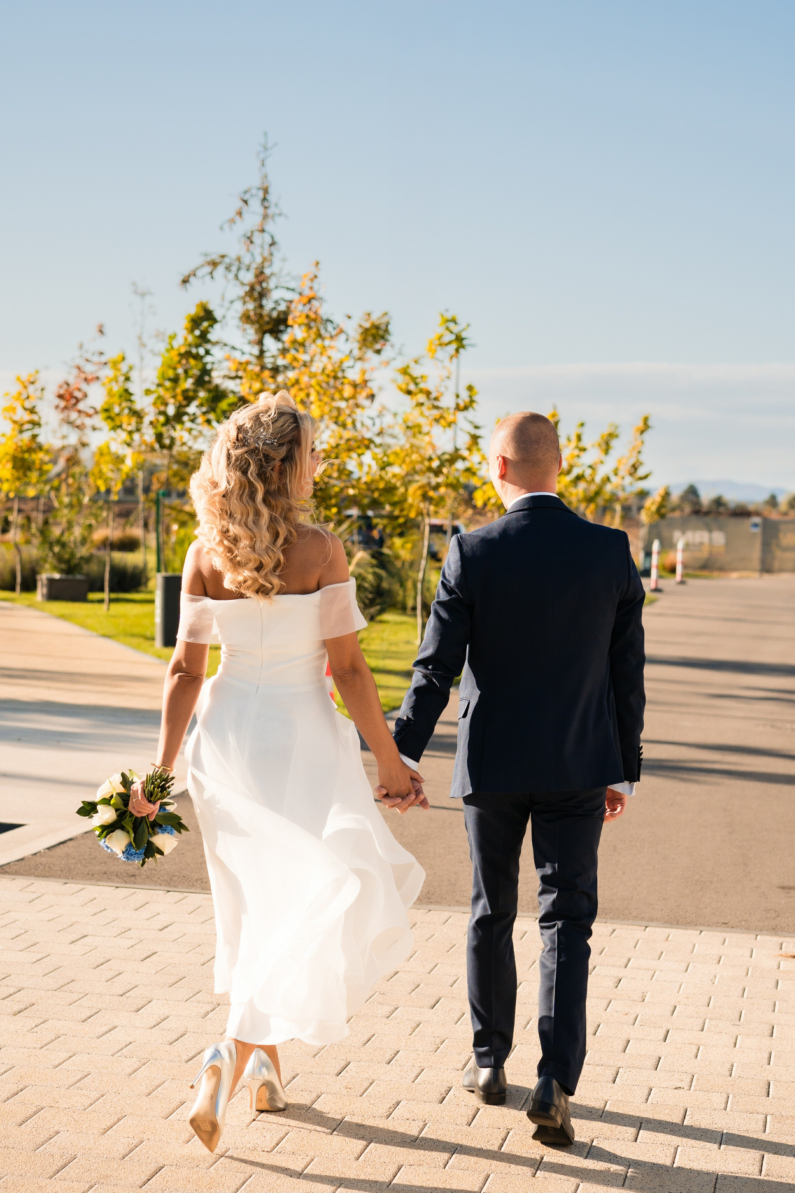 Mireasa râzând în brațele mirelui, într-un peisaj de poveste