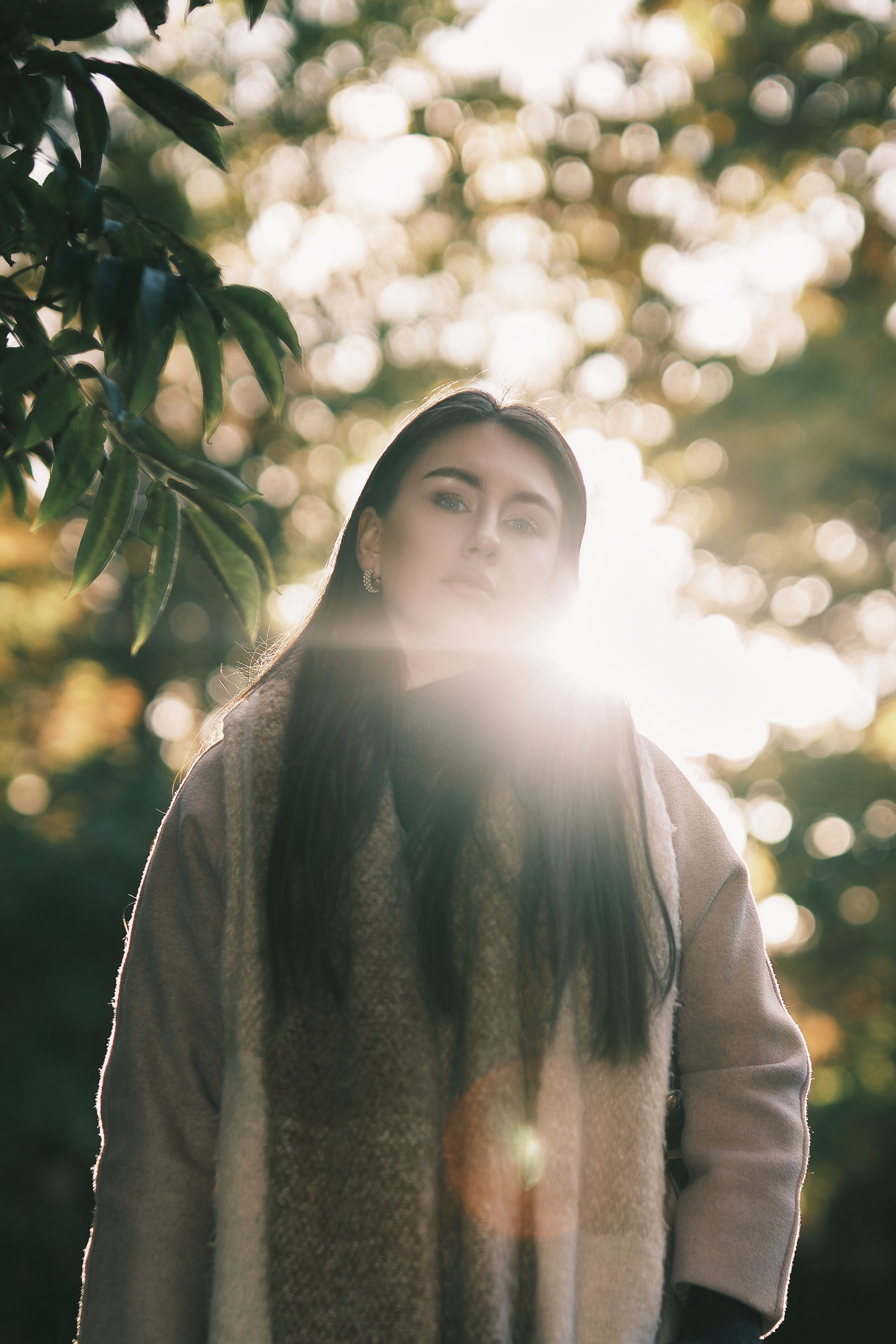 Уличная фотосесия красивая девушка осенью в пальто в костровом свете