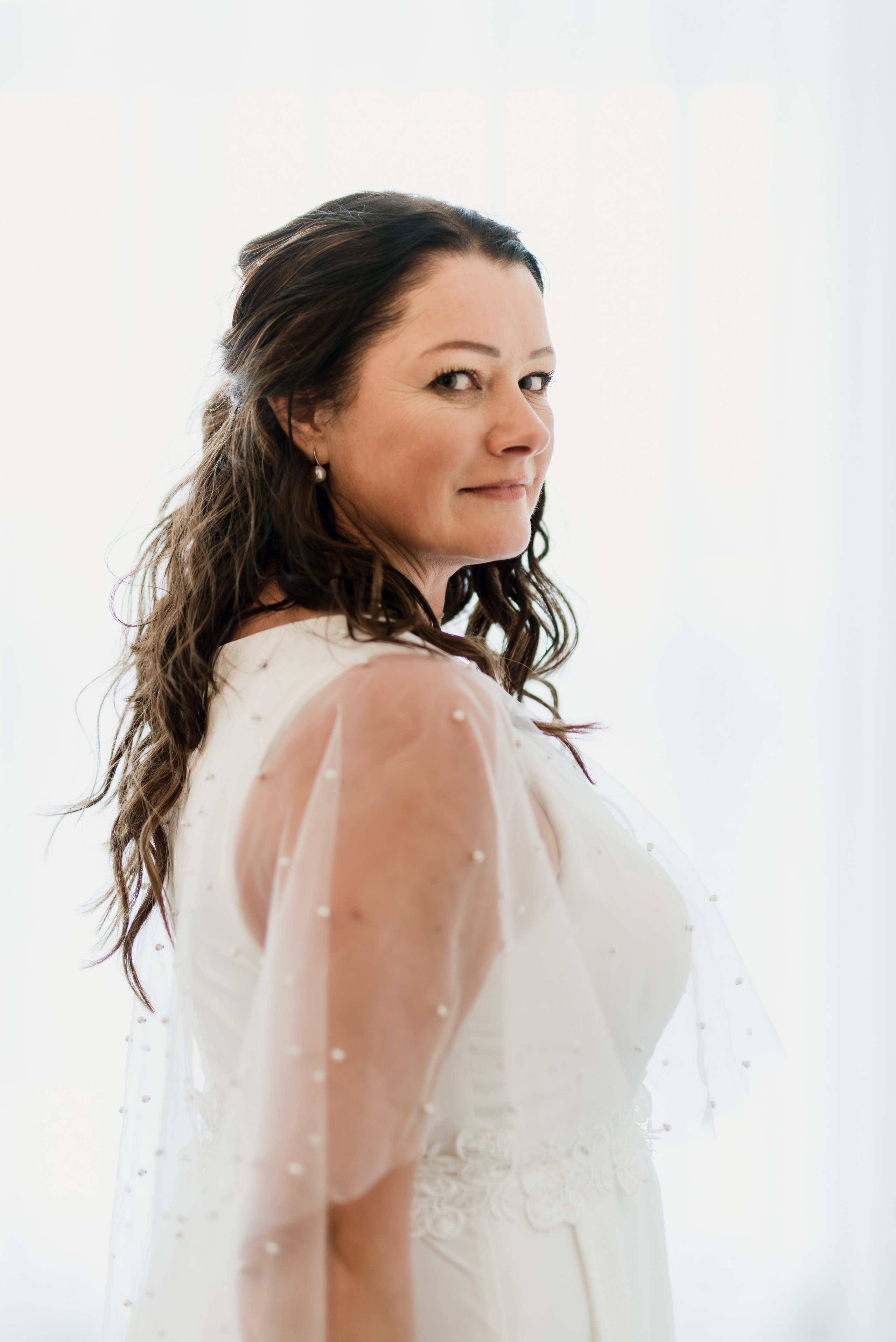 Bride in her wedding dress walking through the rustic halls of Hotel Búðir, the soft lighting creating a dreamy atmosphere.