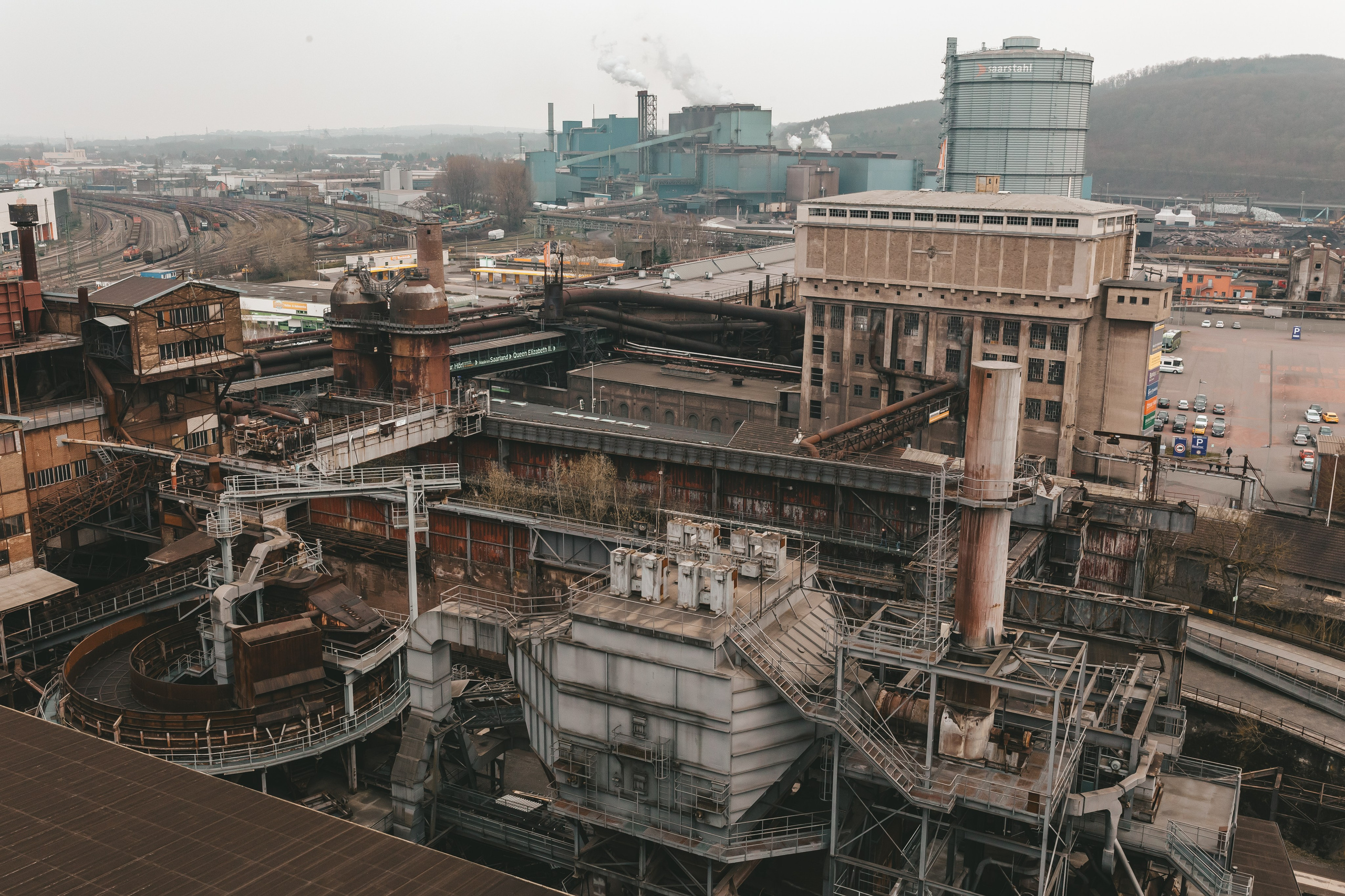 Силуэт заводских конструкций на фоне яркого дневного неба.