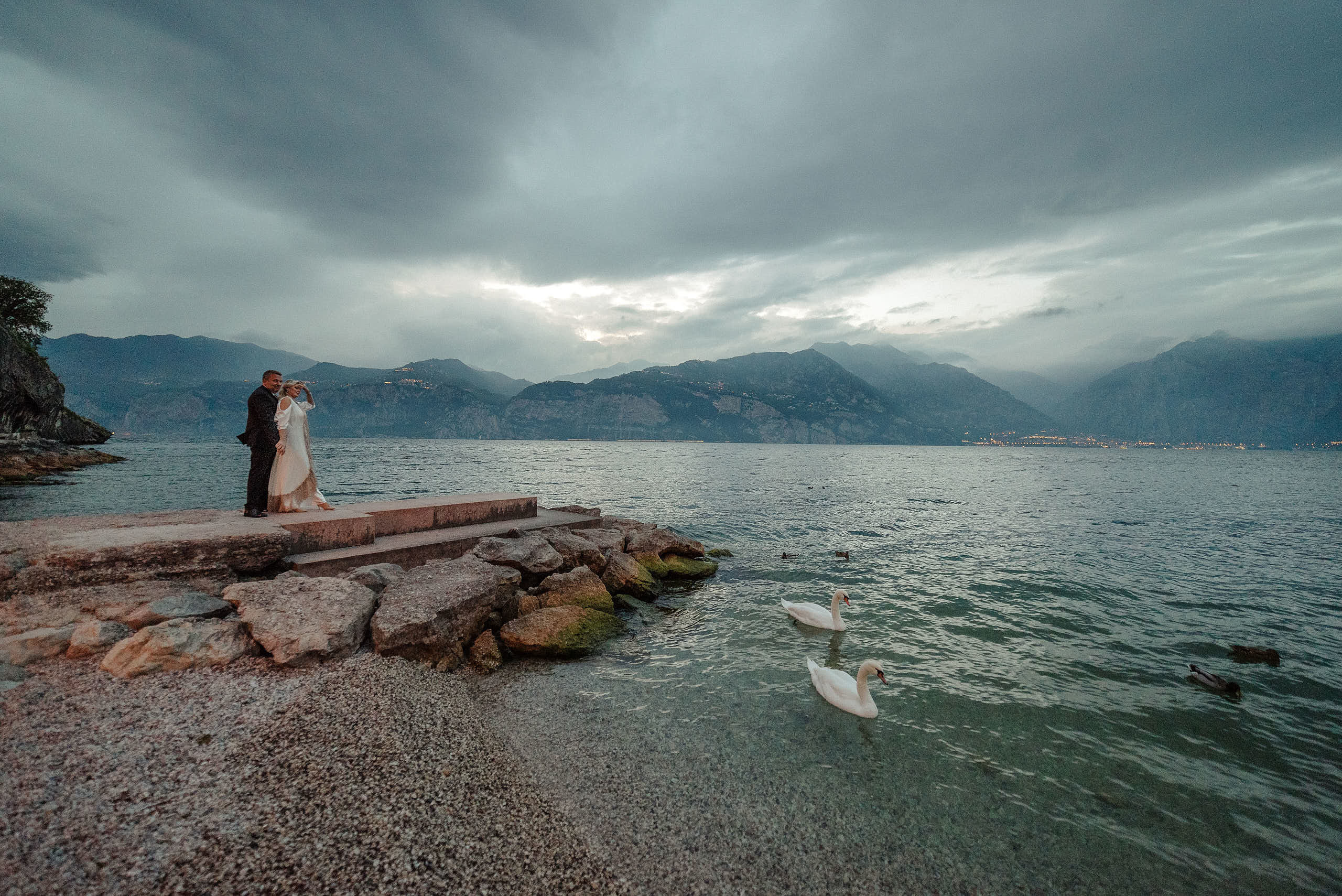  La Sposa e lo sposo in con lo sfondo di Lago di Garda. Fotografo di Matrimonio sul lago di Garda.