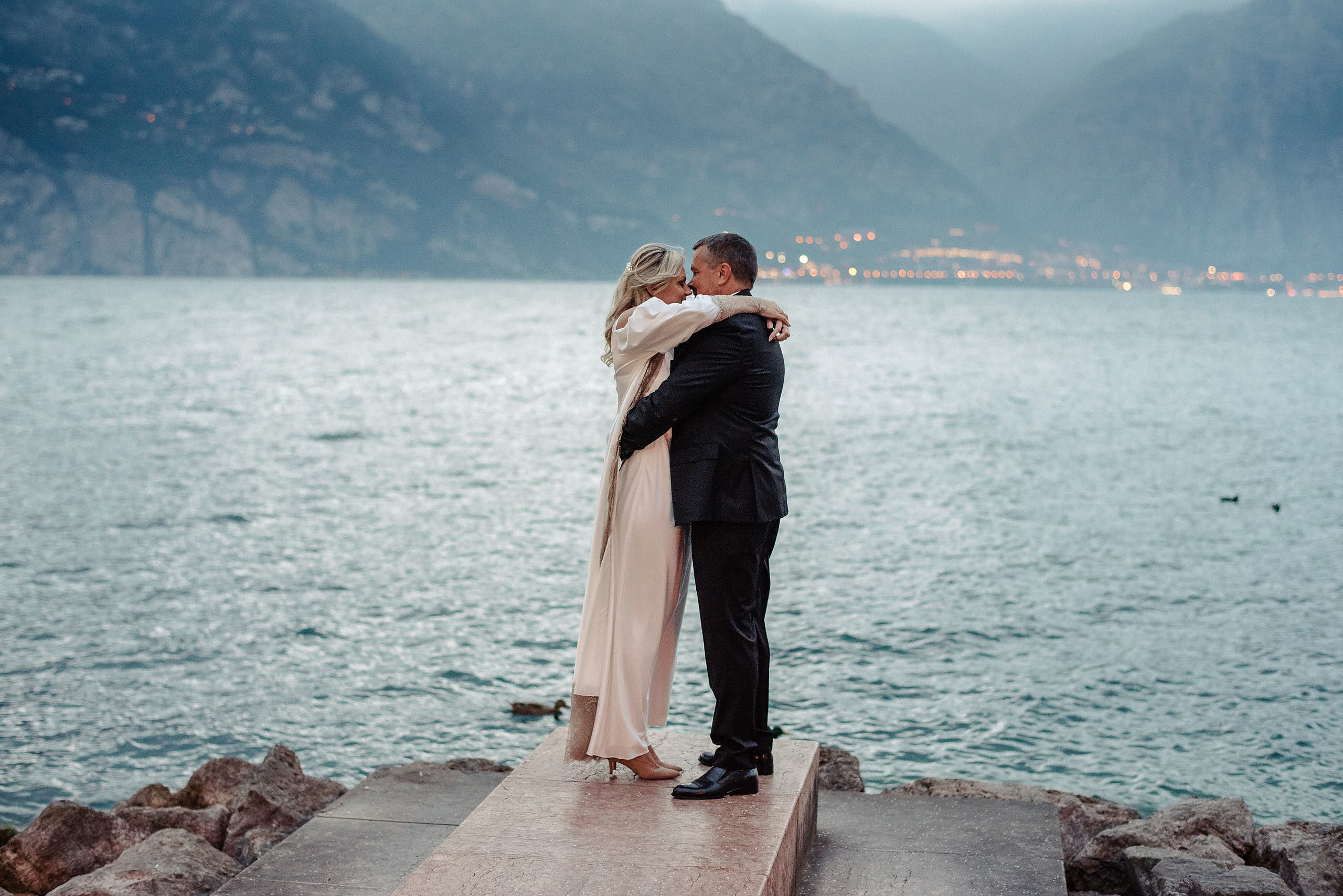  La Sposa e lo sposo in con lo sfondo di Lago di Garda. Fotografo di Matrimonio sul lago di Garda.