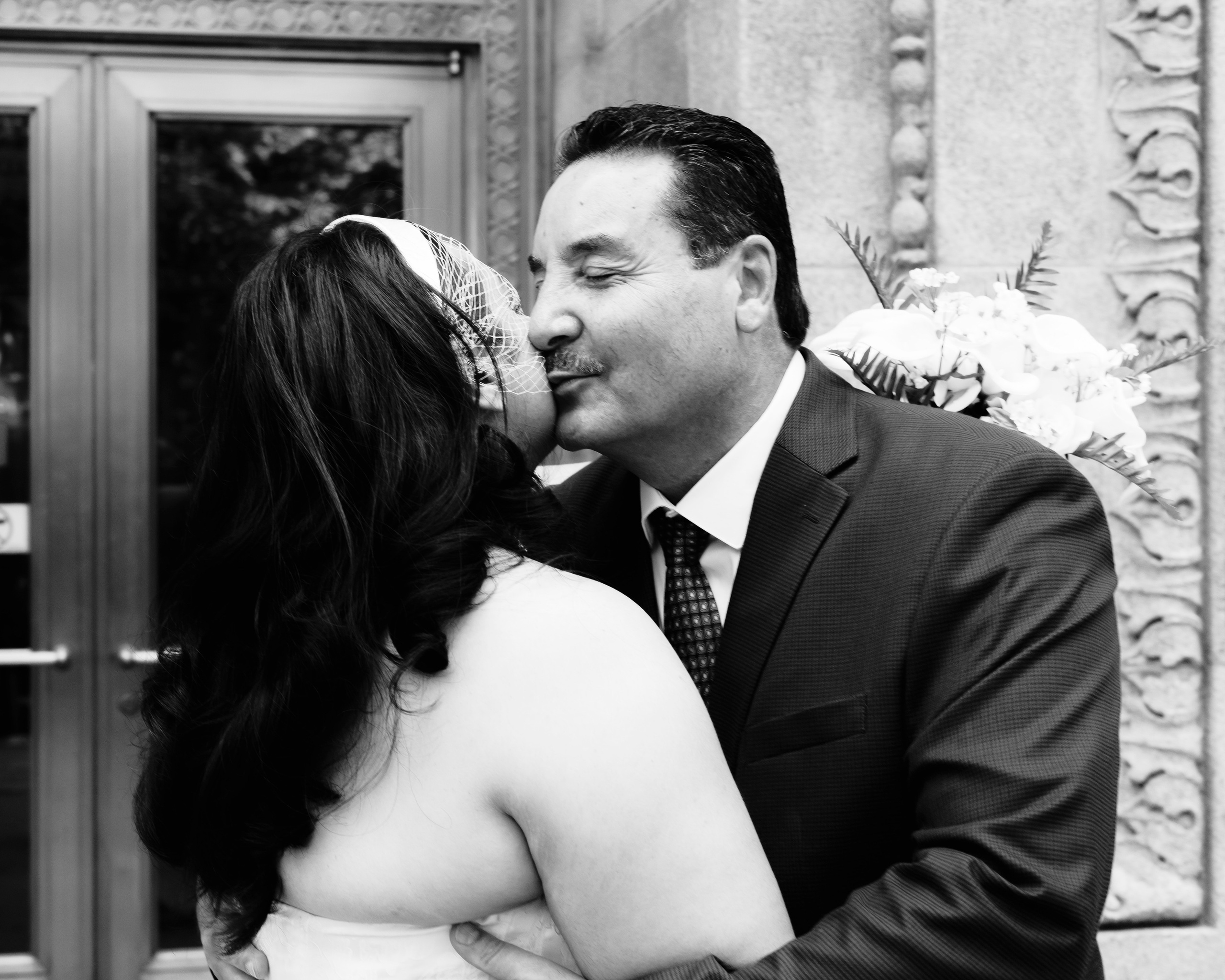 Father kissing bride on the cheek during wedding preparations in Chicago