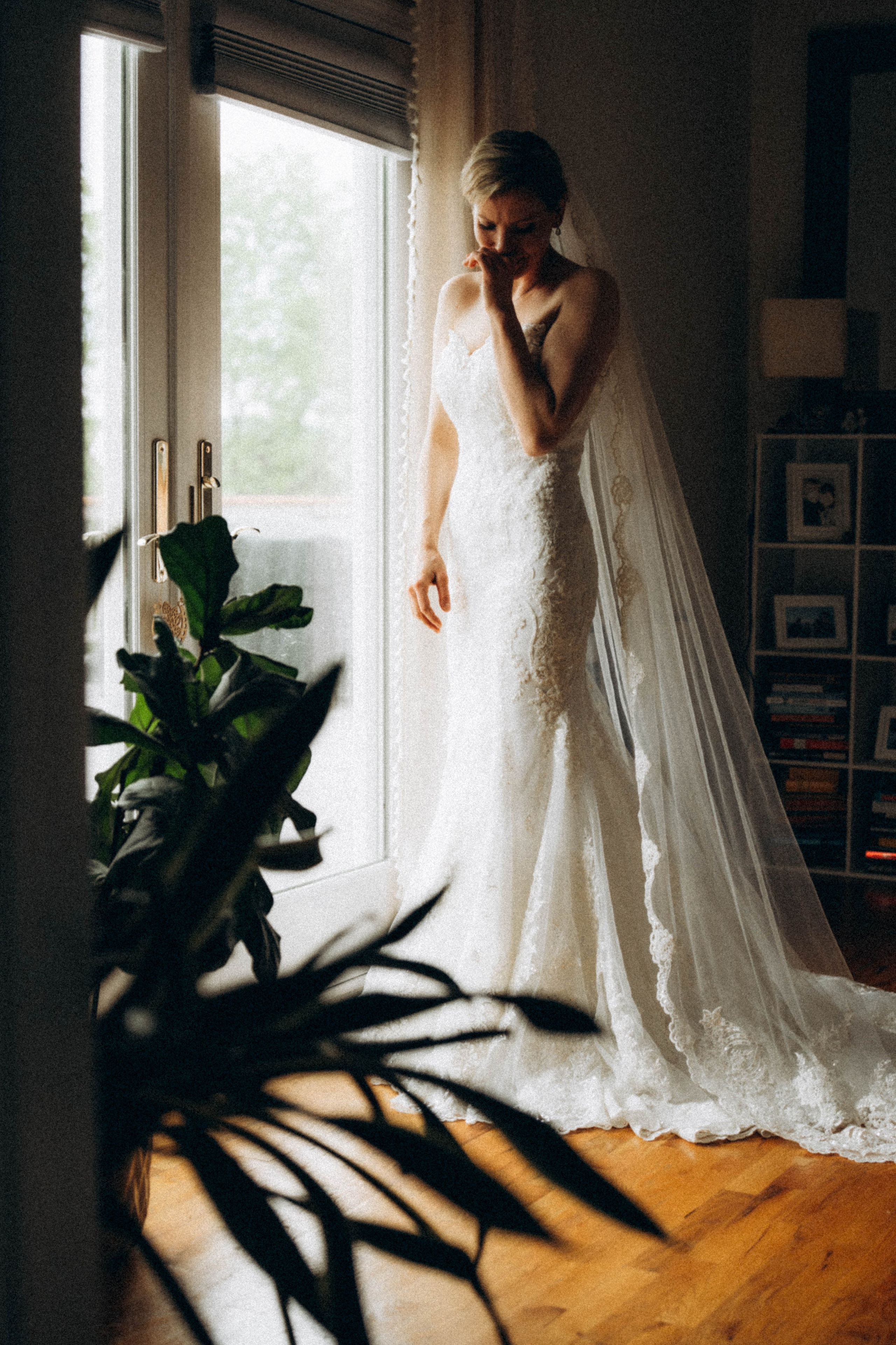 Bride in Syracuse park surrounded by greenery.