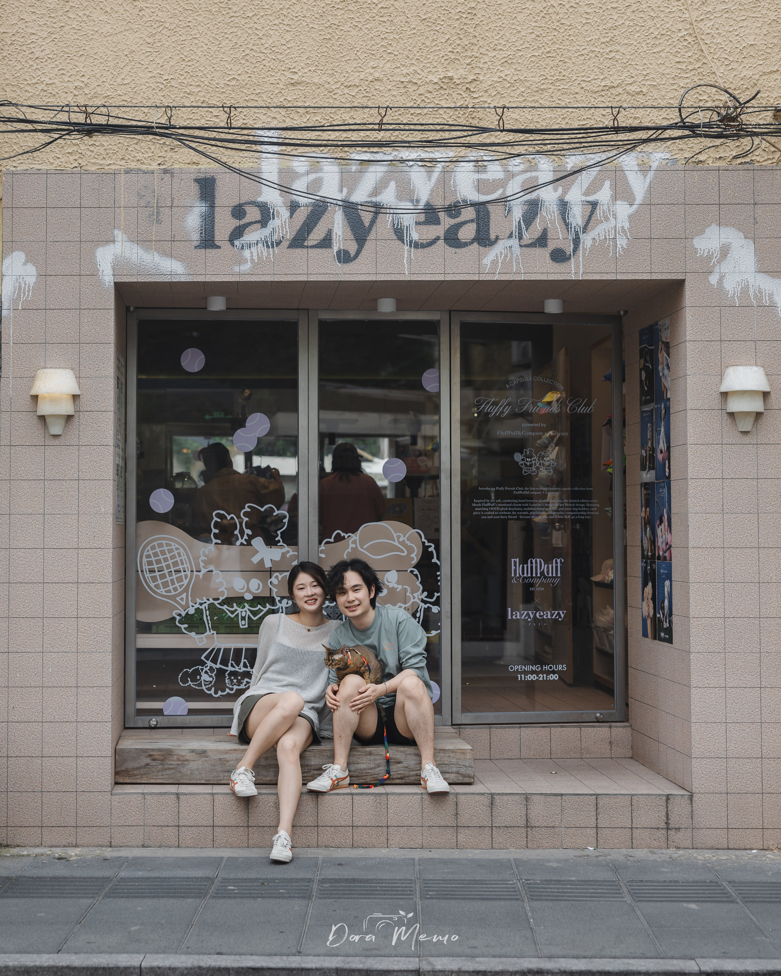 A couple sits with their cat outside a neighborhood storefront in Shanghai, closing the family story with a sense of place