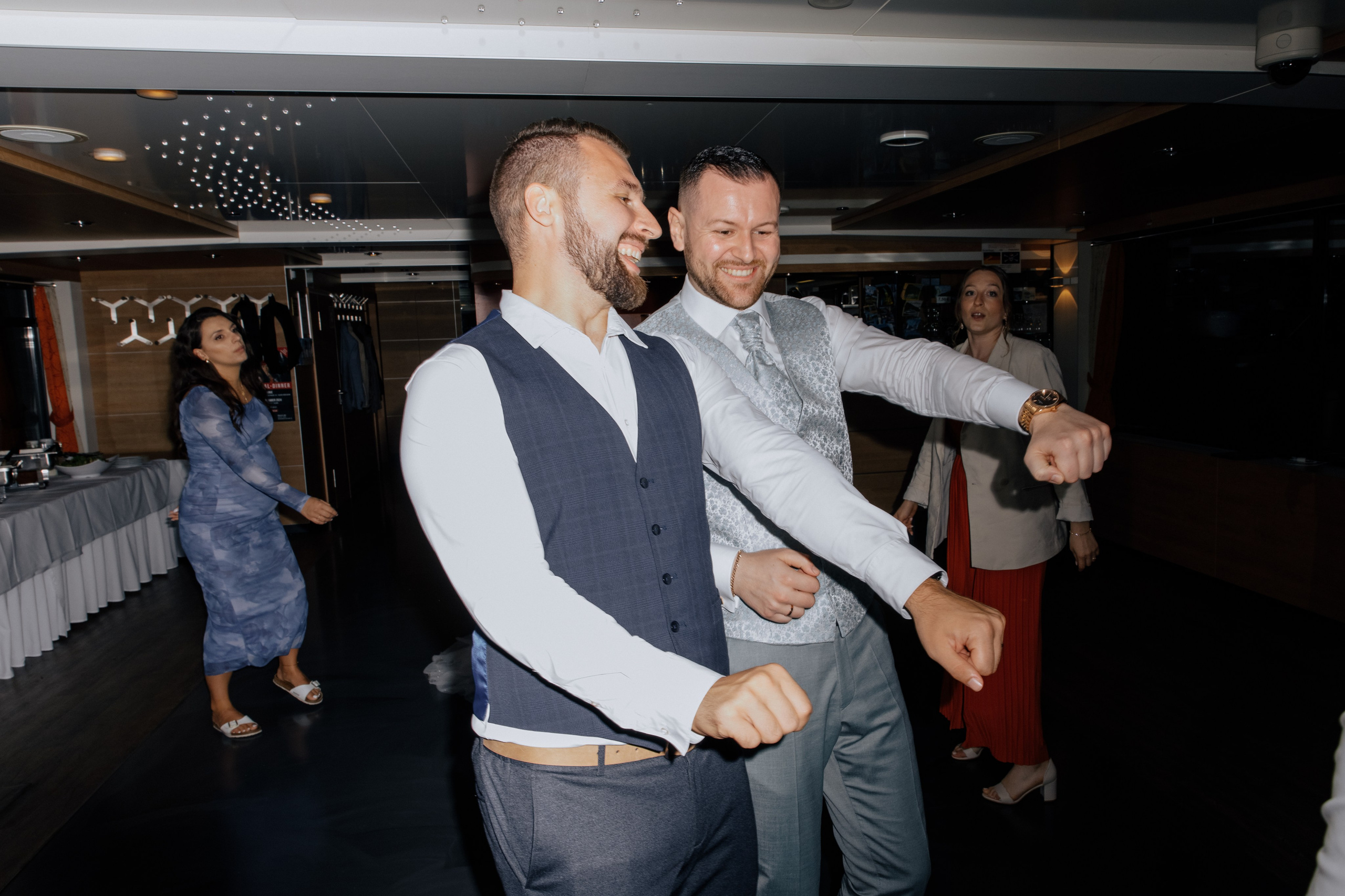 Der Bräutigam tanzt ausgelassen mit einem Freund und lacht. 