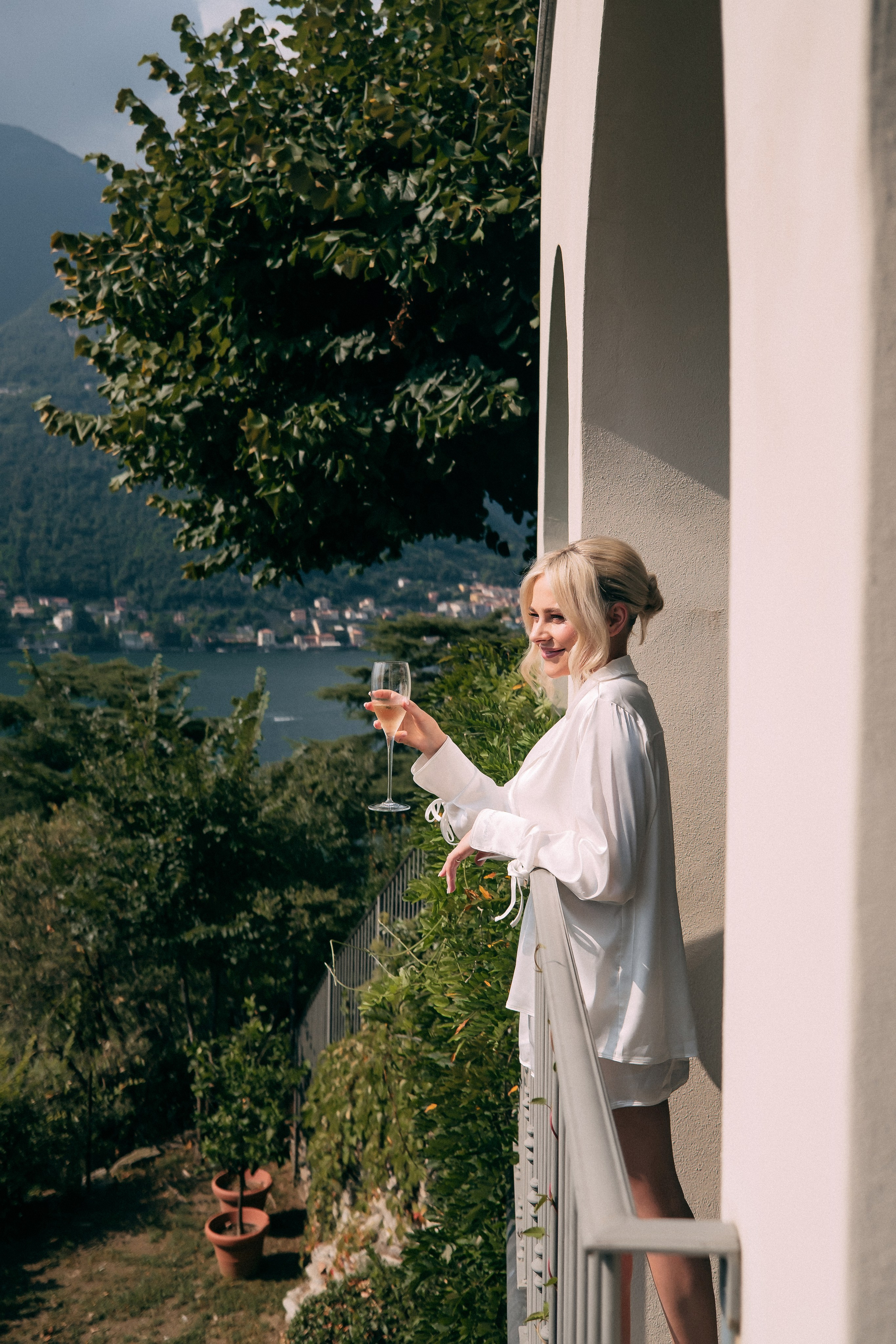 Bride enjoying champagne on the balcony at Villa Lario, Lake Como, Italy
