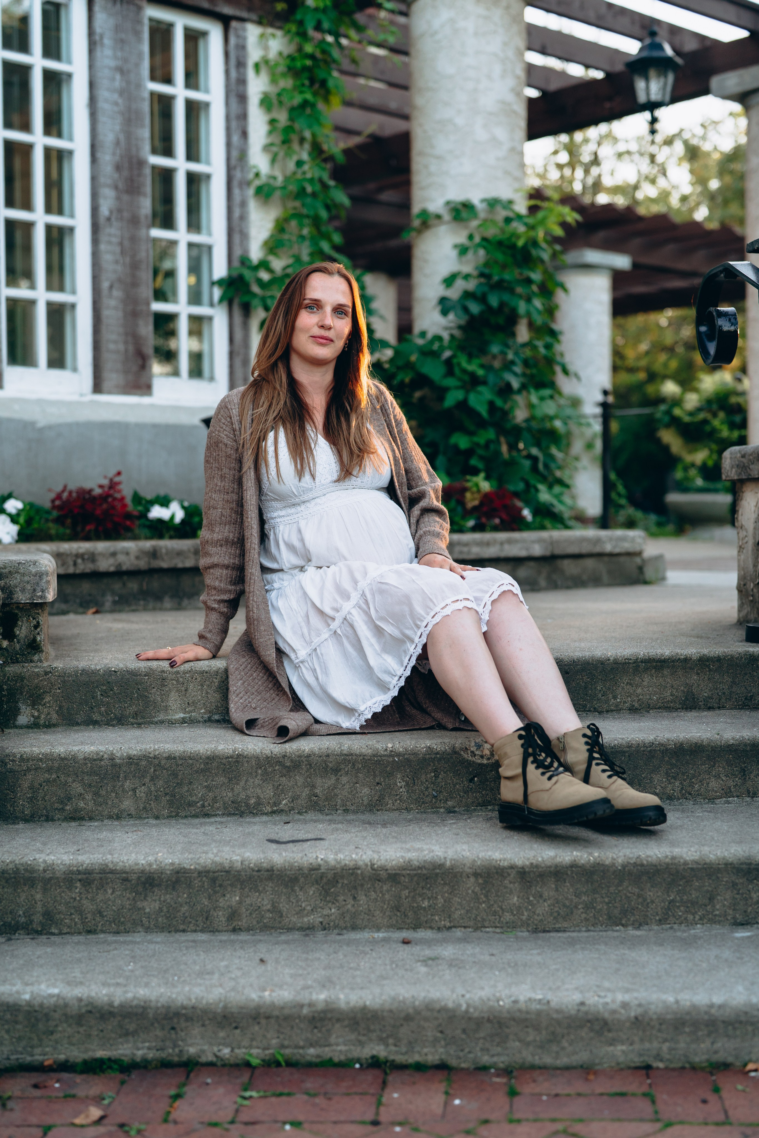 Beautiful woman in white dress and gray cardigan, sitting on a beautiful staircase. Winnipeg Photo Shoot