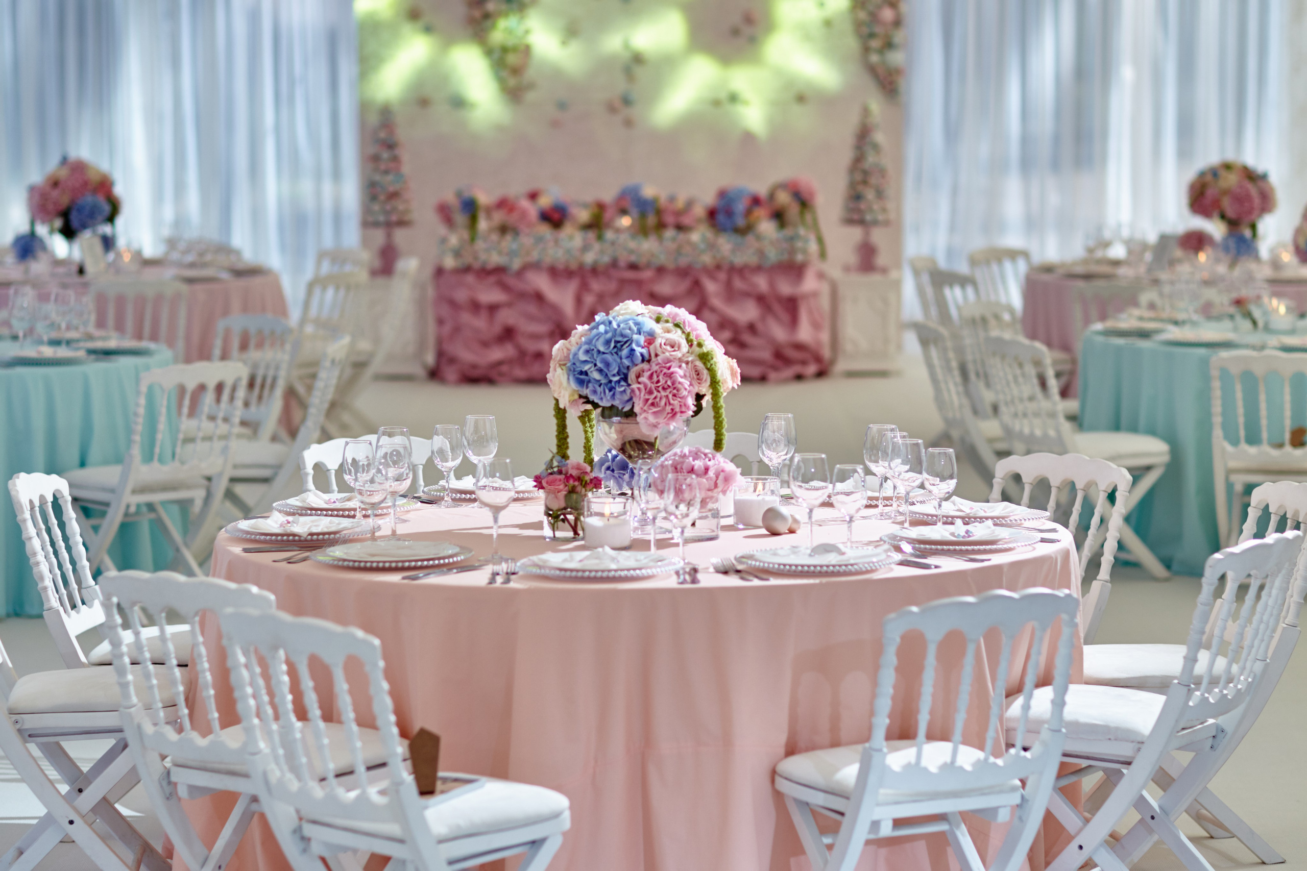 Salle de réception de mariage à Auxerre – tables rondes décorées de fleurs et de linge rose poudré