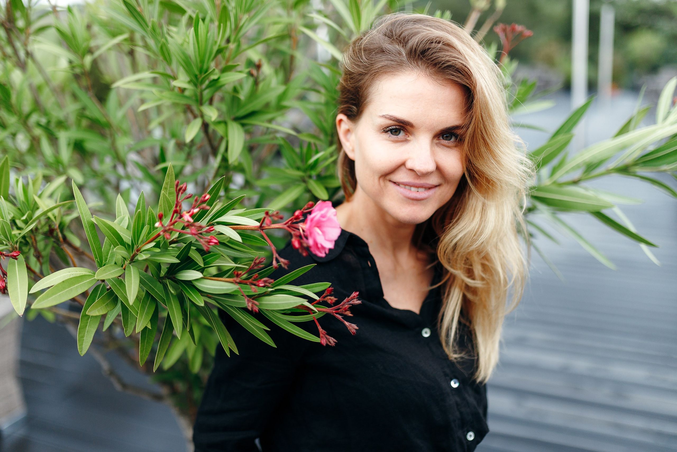 Smiling woman with curly hair near a plant