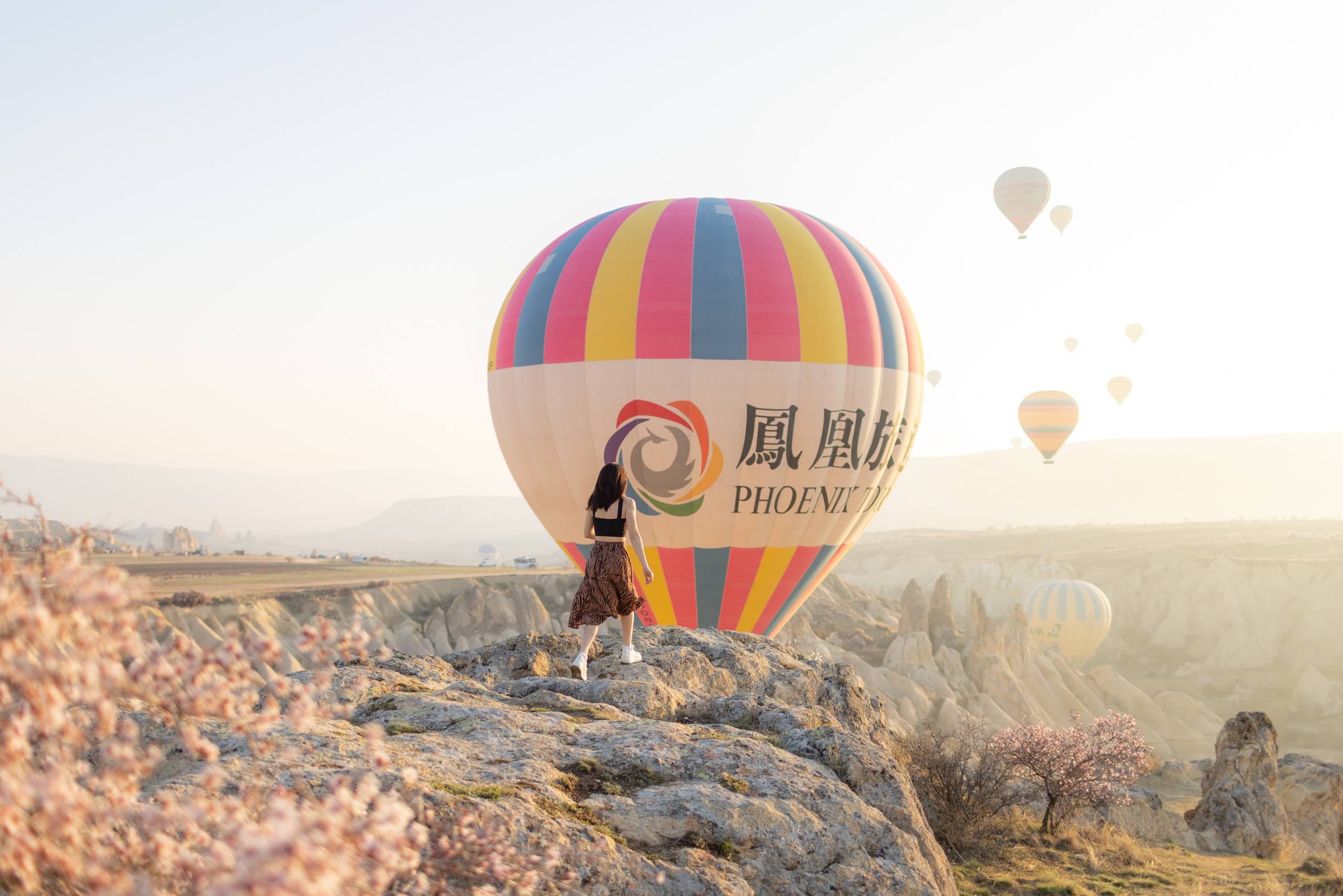 Spring Couple Photoshoot with Hot Air Balloons and Blooming Trees. Julia Ganch I Fashion Wedding Photography I Cappadocia Turkey
