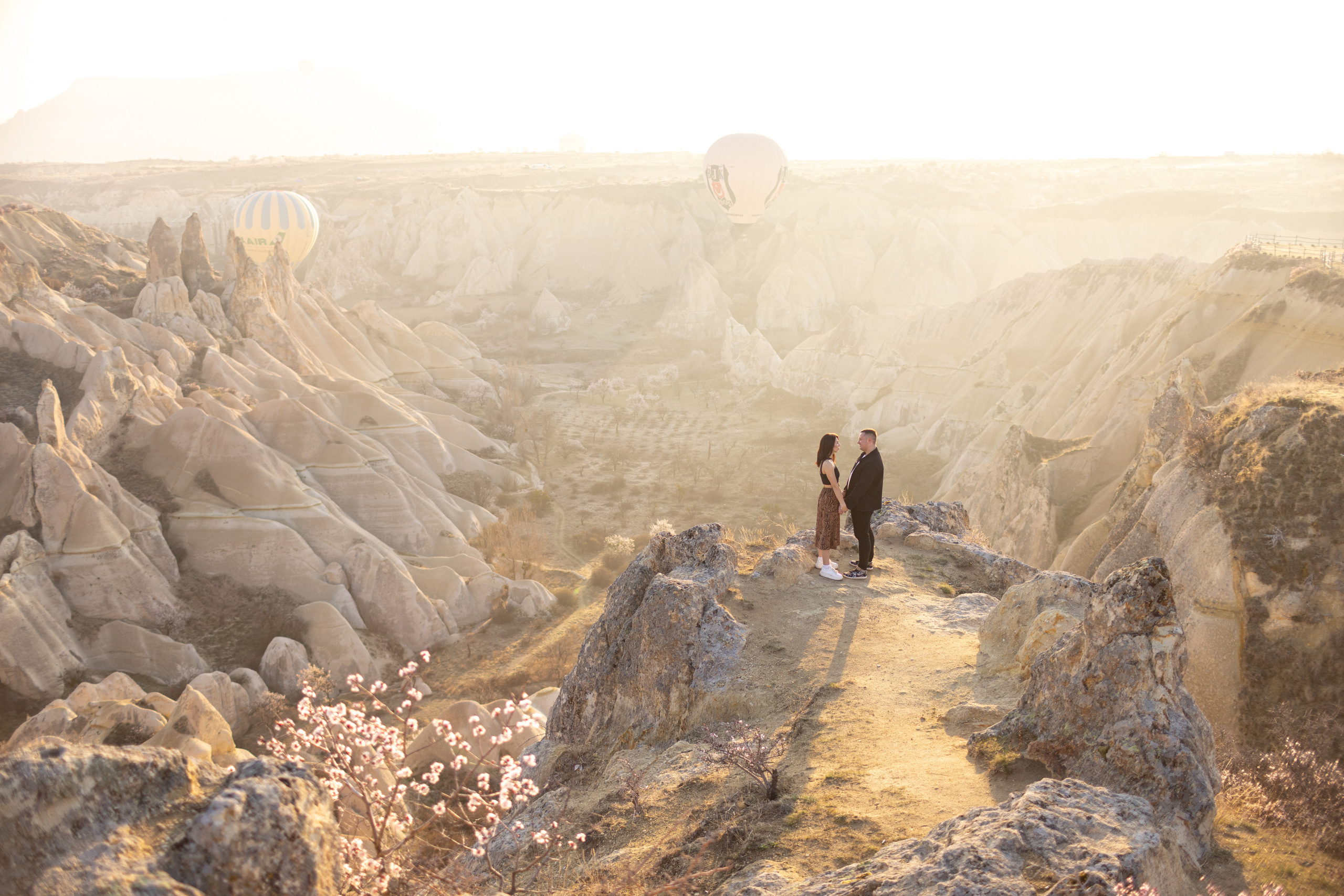 Spring Couple Photoshoot with Hot Air Balloons and Blooming Trees. Julia Ganch I Fashion Wedding Photography I Cappadocia Turkey