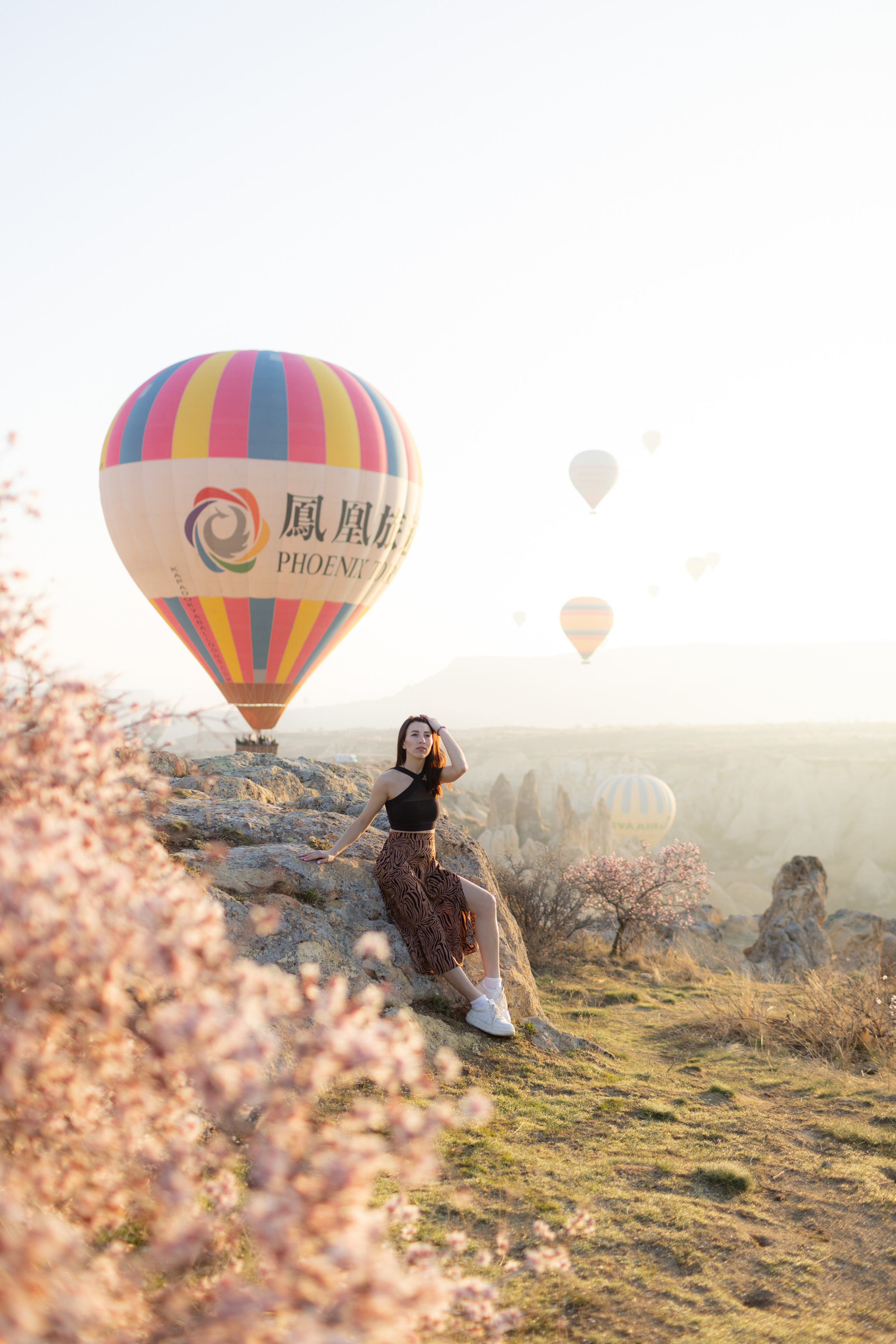 Spring Couple Photoshoot with Hot Air Balloons and Blooming Trees. Julia Ganch I Fashion Wedding Photography I Cappadocia Turkey