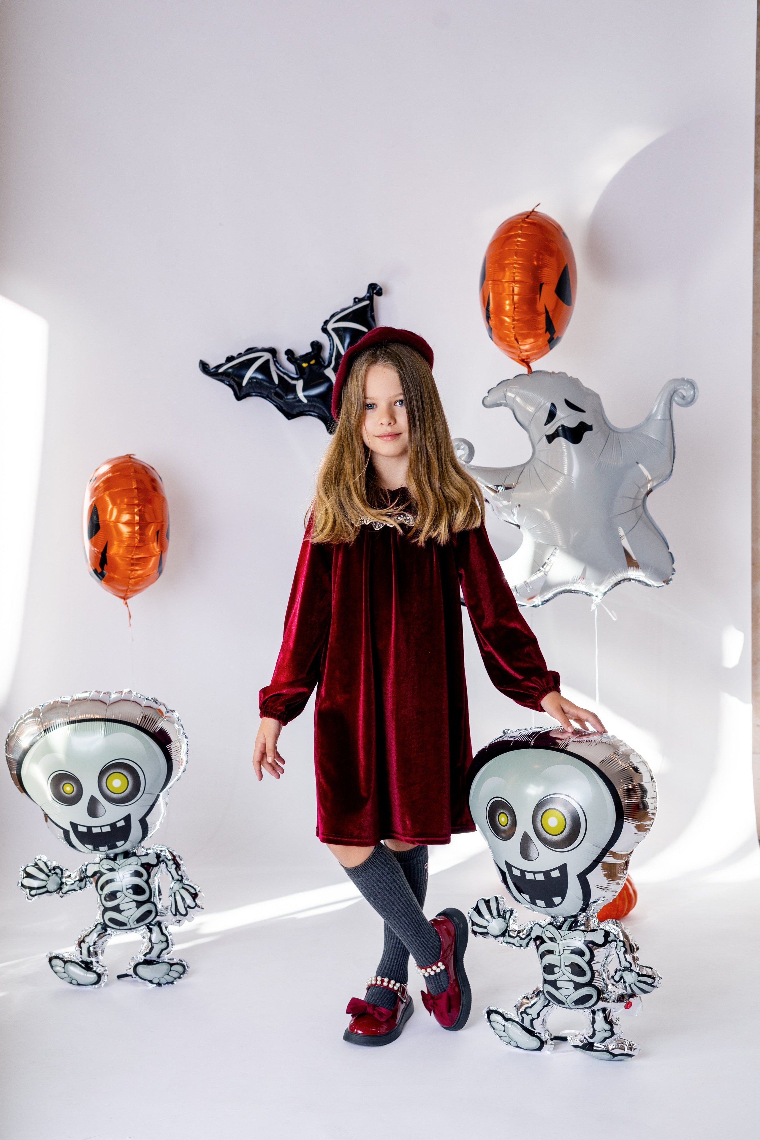 Portrait d’enfant déguisé pour Halloween en studio photo	•	Enfant souriant en costume Halloween avec décor festif	•	Petite fille posant avec accessoires Halloween studio photo à Roanne