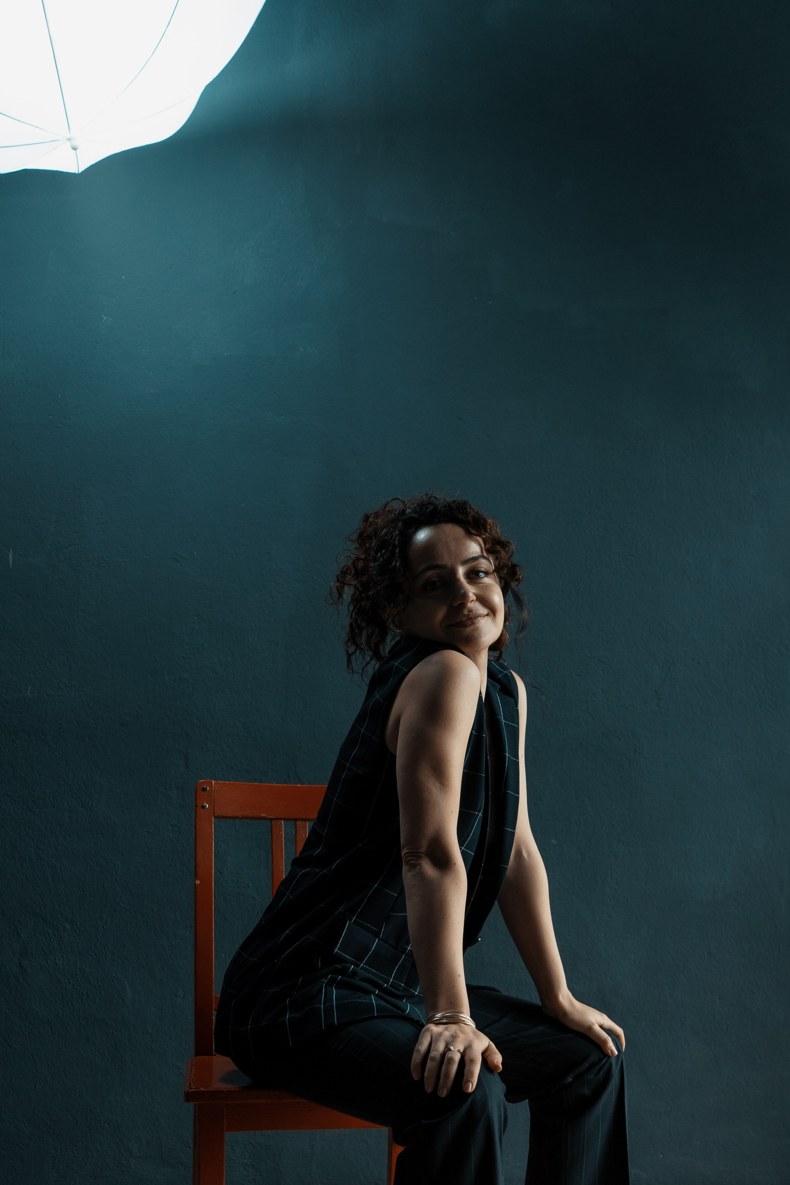 Studioaufnahme – Frau sitzt auf rotem Stuhl, intensiver Blick nach oben – Portrait Dresden