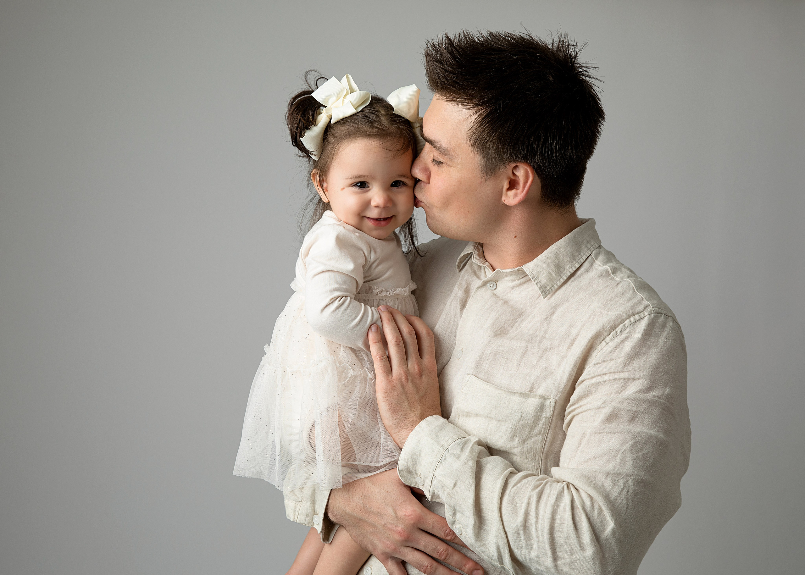 Skapa varaktiga minnen med en familjefotografering som inkluderar mamma, pappa och barn i studion.