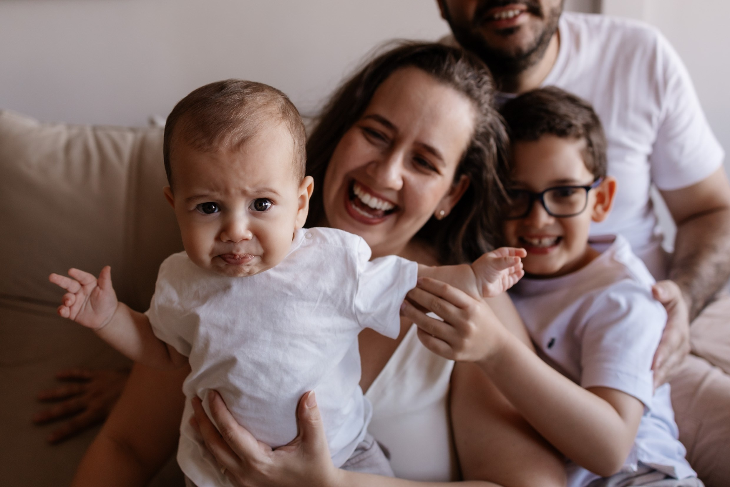 Família reunida em momento de brincadeira com o bebê.
