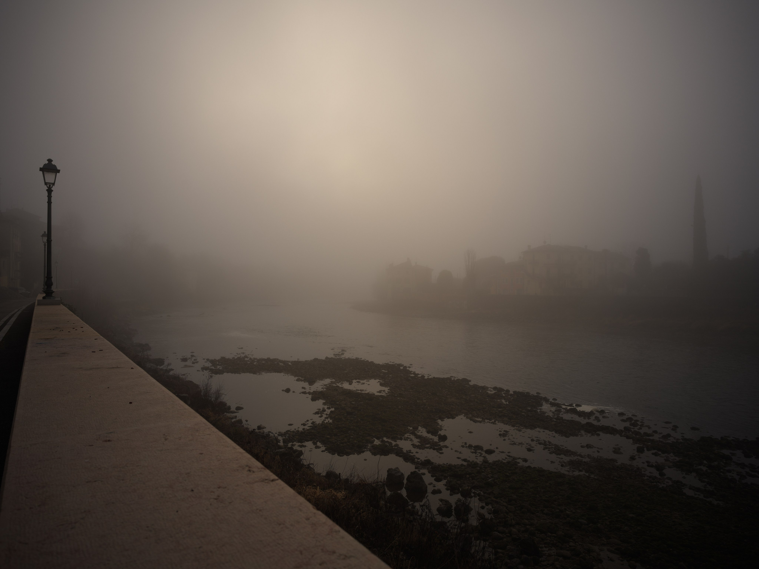 A quiet winter morning along the Adige river in Verona. Soft fog, minimal composition and atmospheric light create a timeless fine art piece for refined interiors.