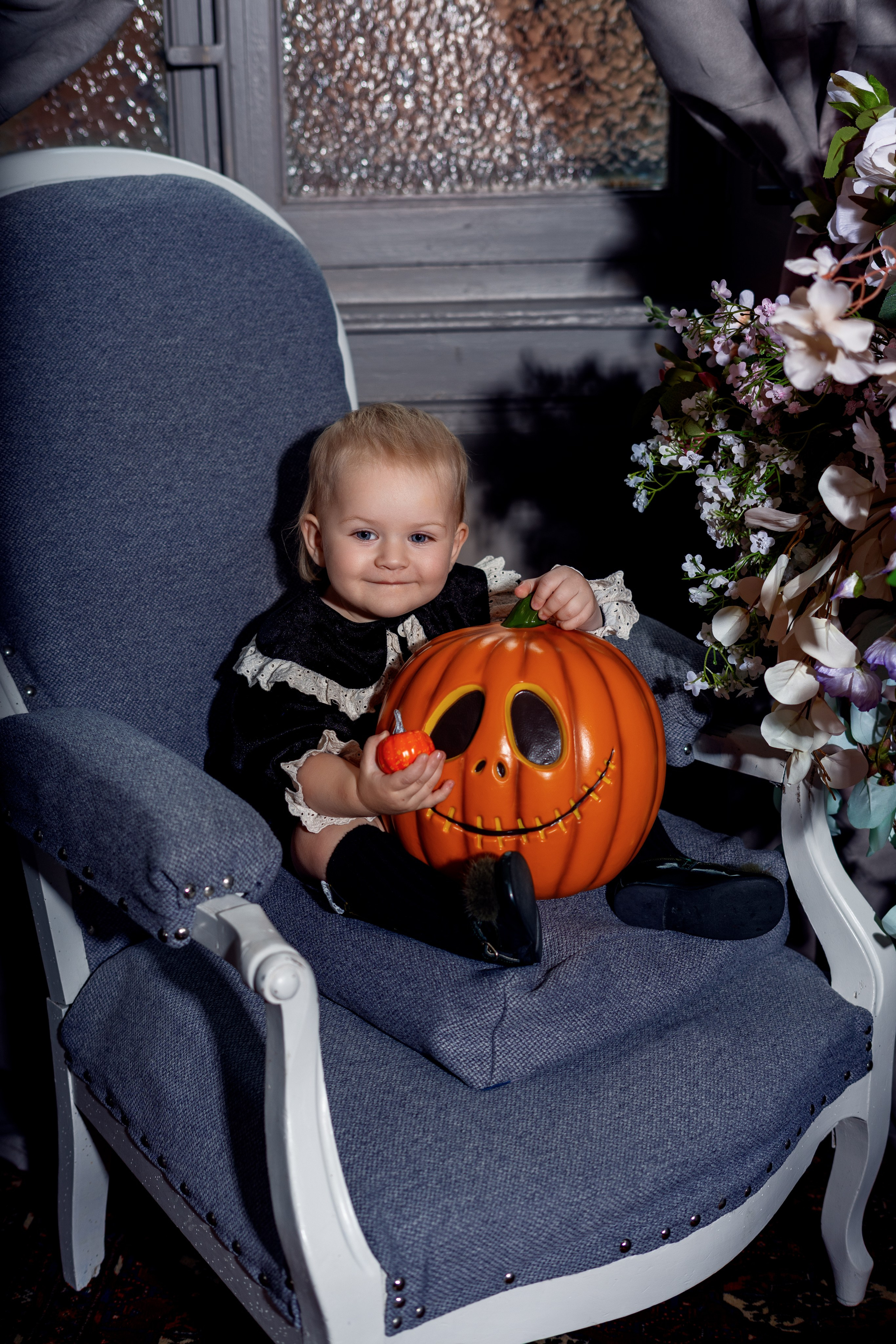 Enfant dans un décor Halloween sombre avec bougies et fleurs	•	Portrait artistique d’enfant dans une ambiance Halloween élégante	•	Enfant à table avec décoration Halloween et éclairage dramatique studio à roanne