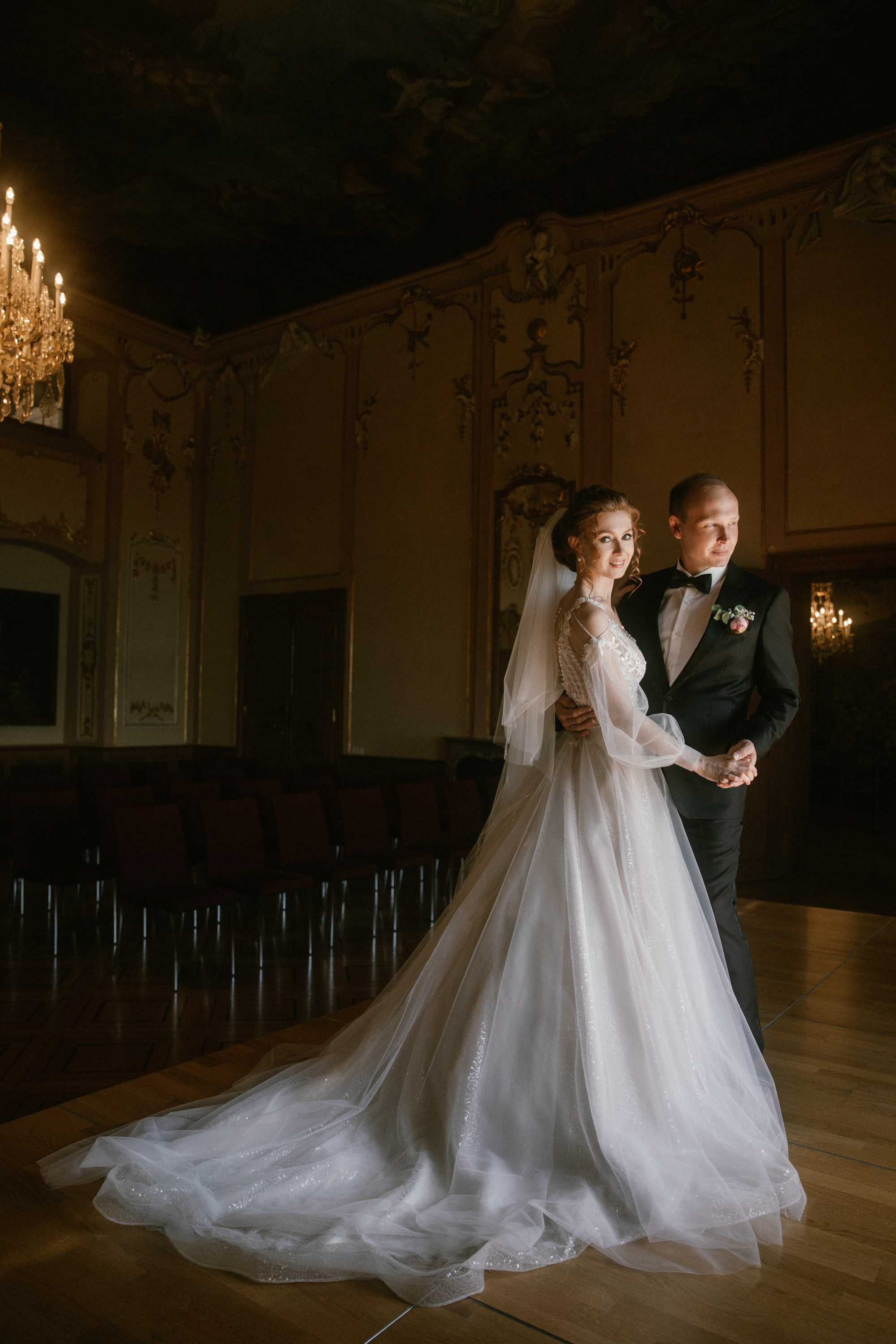 Braut dreht sich mit Bräutigam im Kronleuchterlicht von Schloss Meersburg