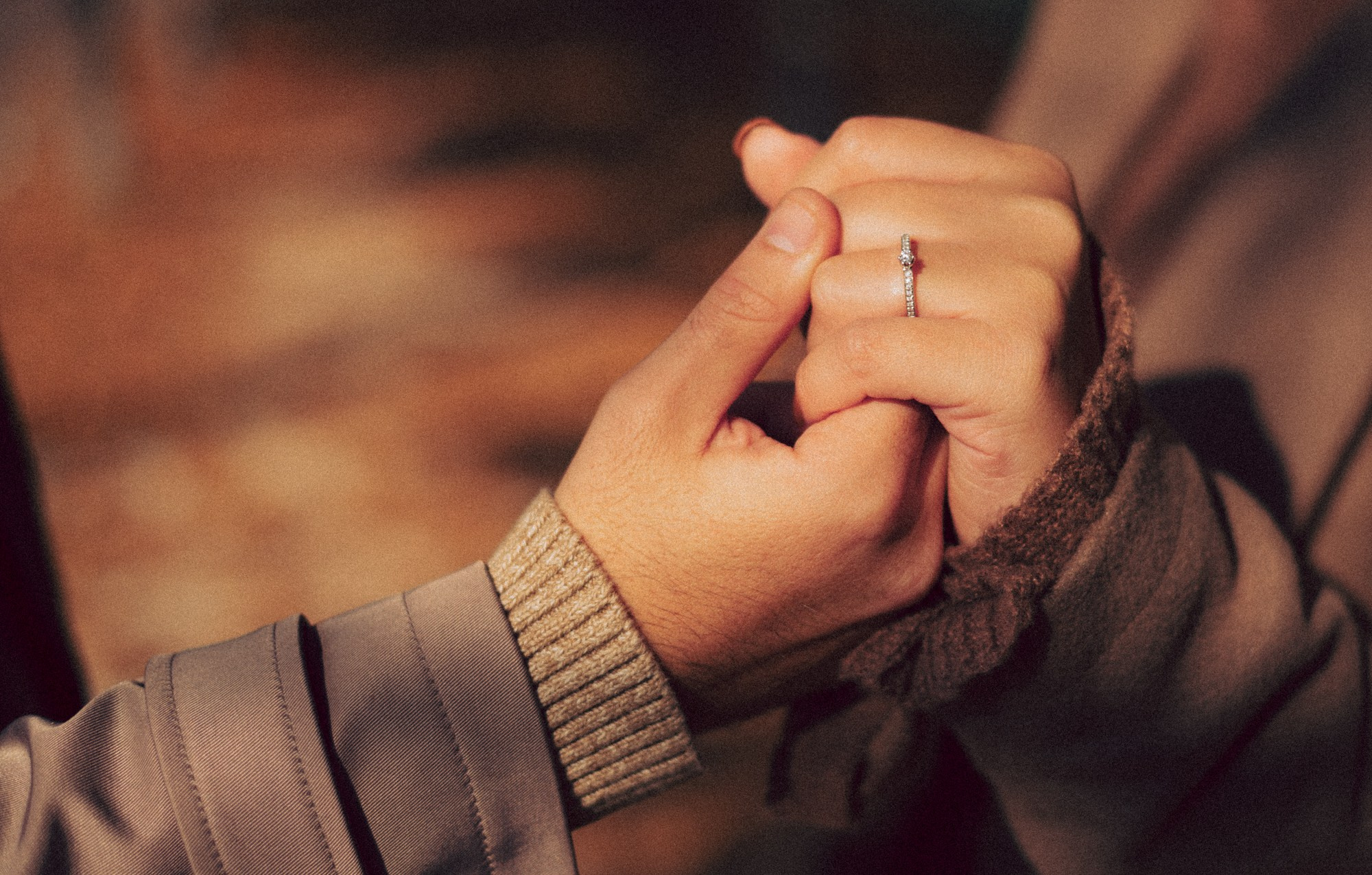 Engagement Ring Close-Up — Romantic Fall Couple Photography. A warm and intimate close-up of a couple holding hands during a fall photoshoot. The engagement ring sparkles in the soft autumn light, capturing a tender and emotional moment. Perfect inspiration for engagement photography, fall couple sessions, proposal shoots, and romantic detail shots. engagement ring photo, couple hands close up, fall engagement session, romantic detail shot, autumn couple photography, engagement photography ideas, cozy fall photoshoot, couple holding hands, natural light photography, warm tones aesthetic