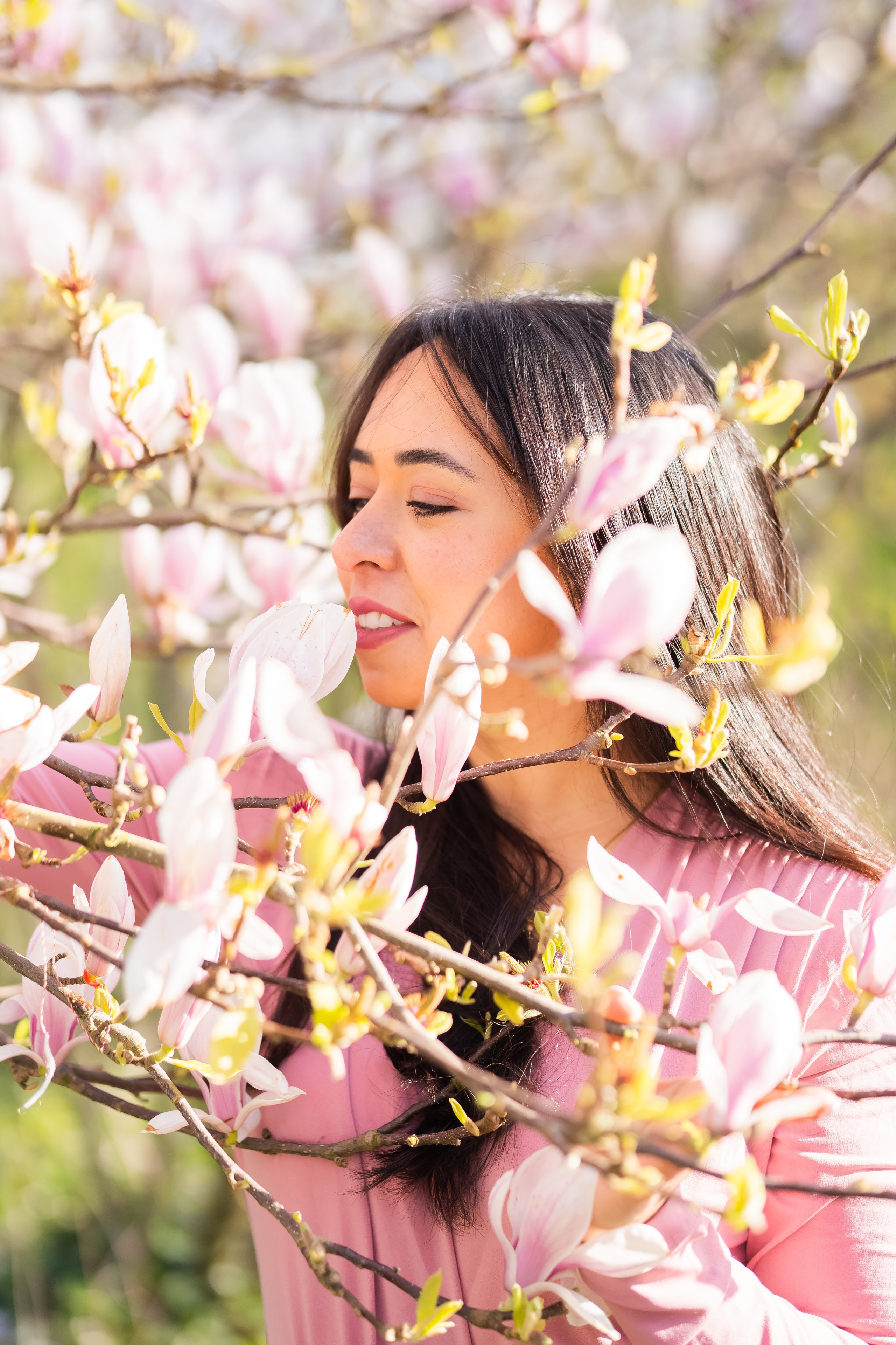 girl holding a branch in a cherry blossoms garden in Netherlands