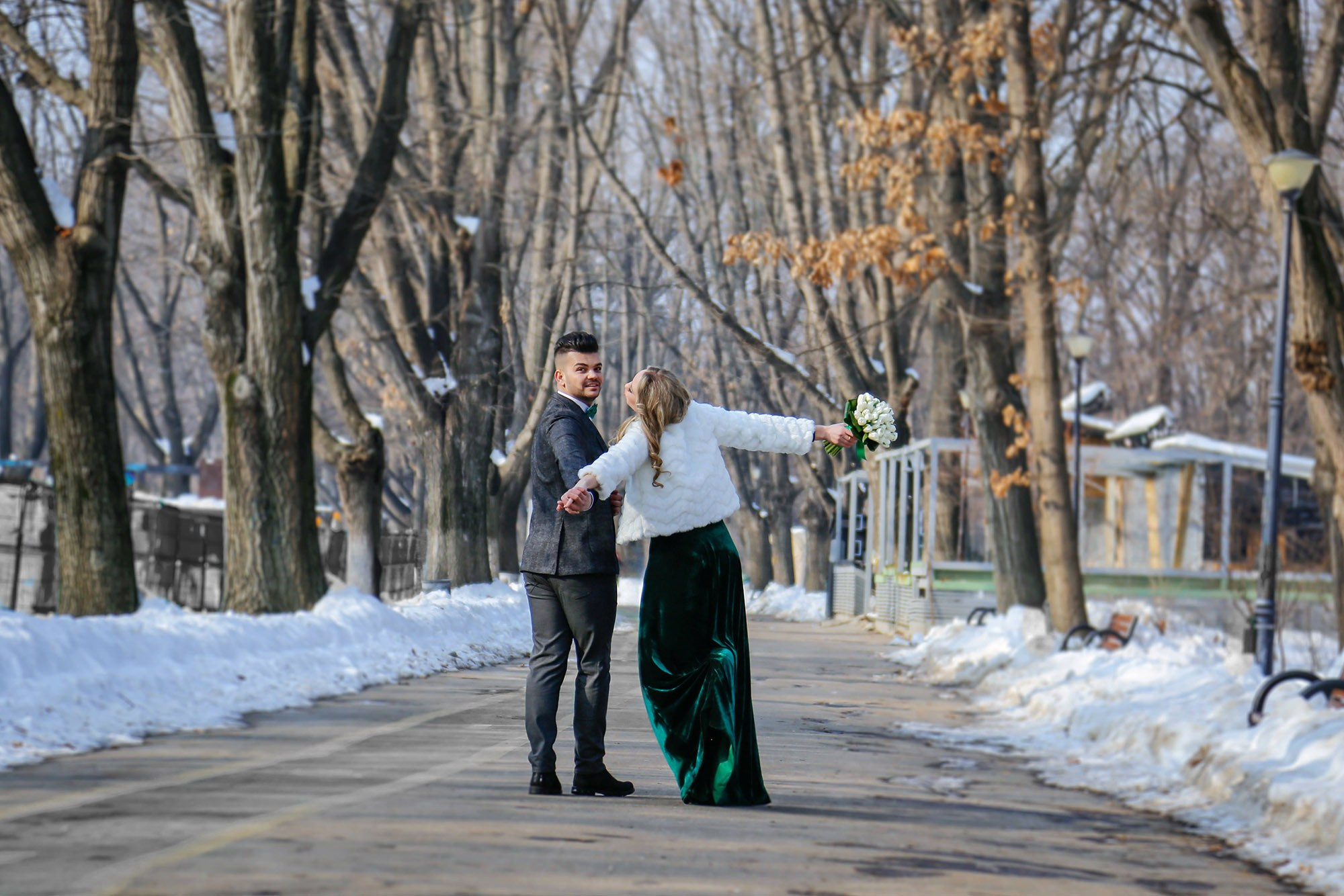 Fun and lively shot of the bride and groom running hand in hand through the snow, capturing the pure joy of the day.