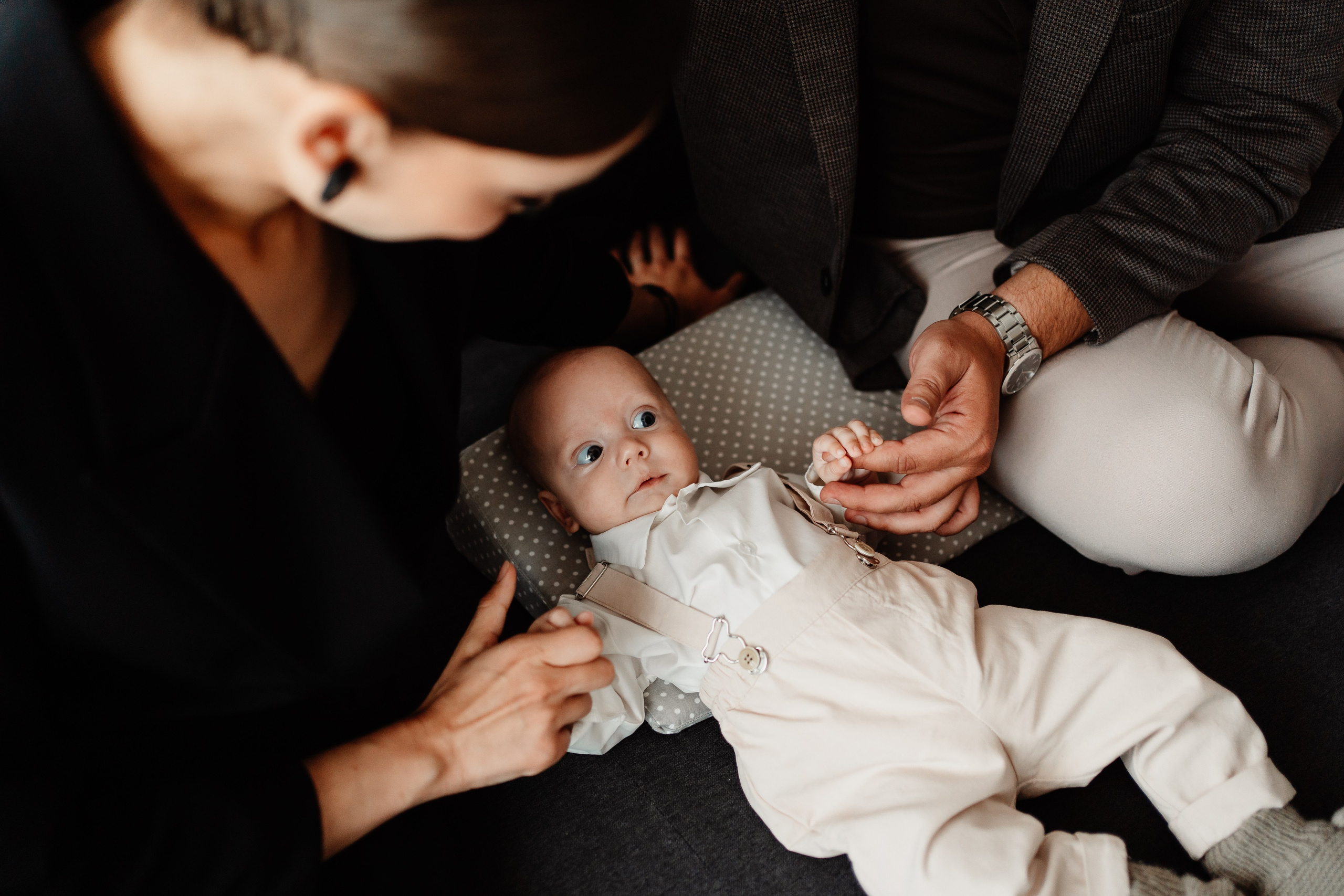 Instantaneu plin de tandrețe dintre părinți și bebeluș în ziua botezului, realizat în Craiova. Fotografie profesională de botez, capturând emoțiile autentice ale familiei într-un decor luminos și cald