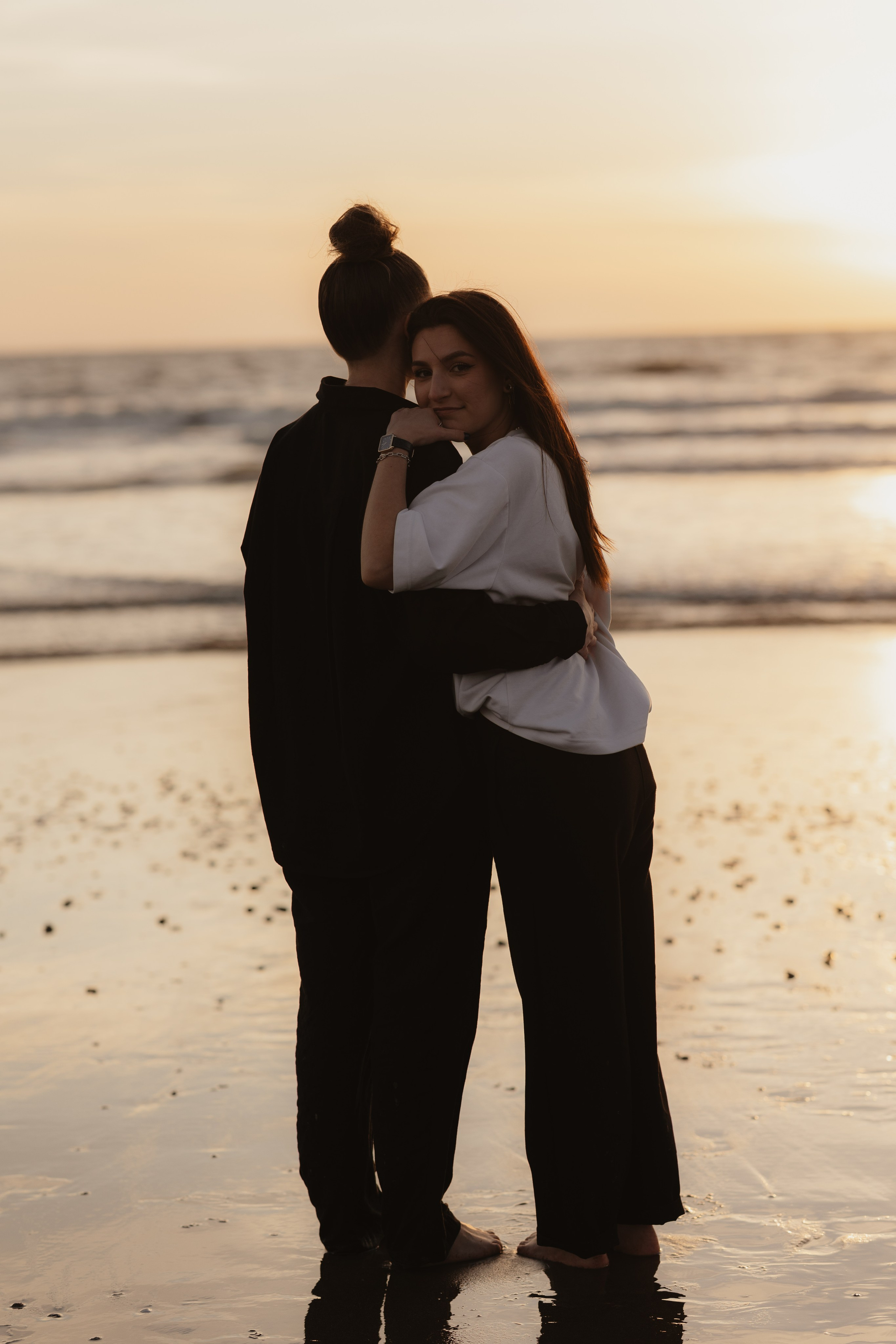 Deux femmes complices à la plage au coucher du soleil, photographie de couple naturelle