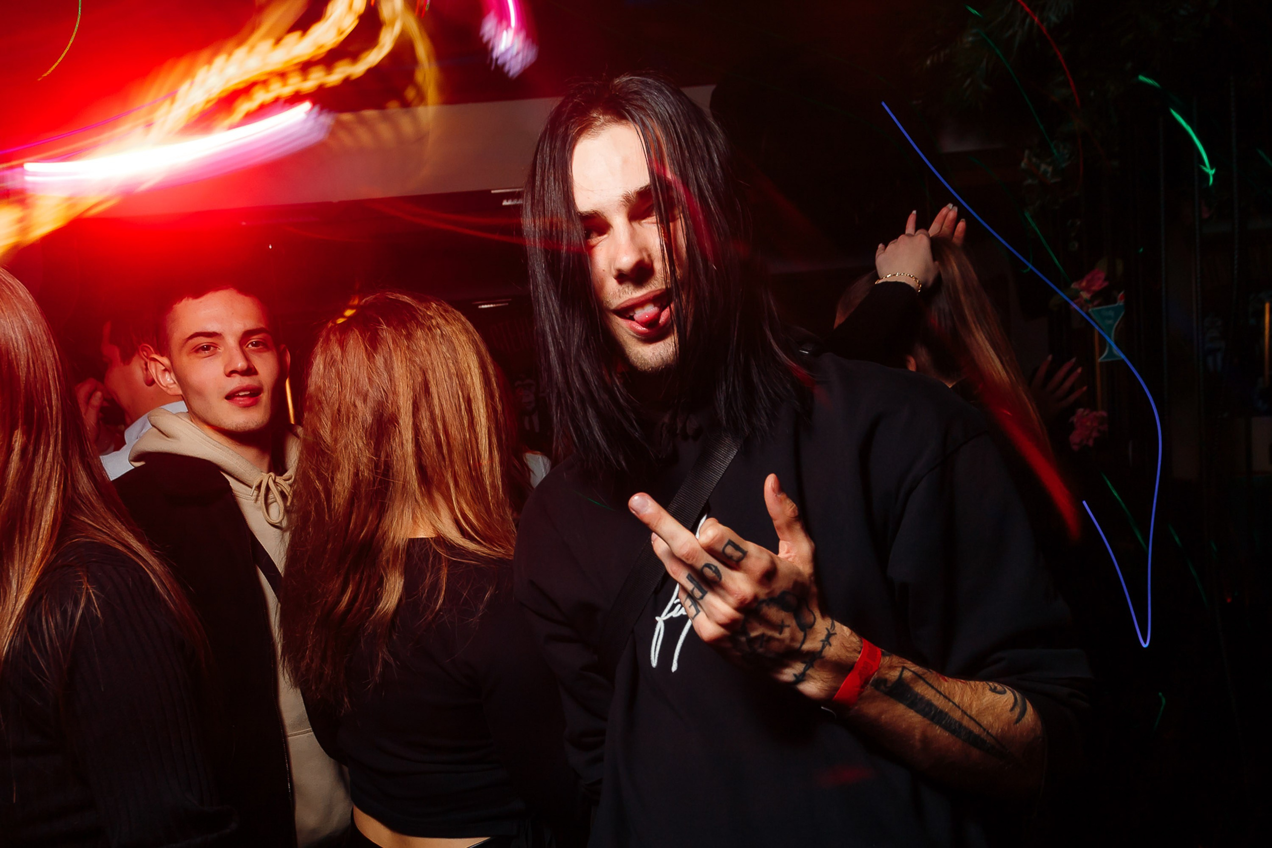 DJ performing with crowd dancing, red lights