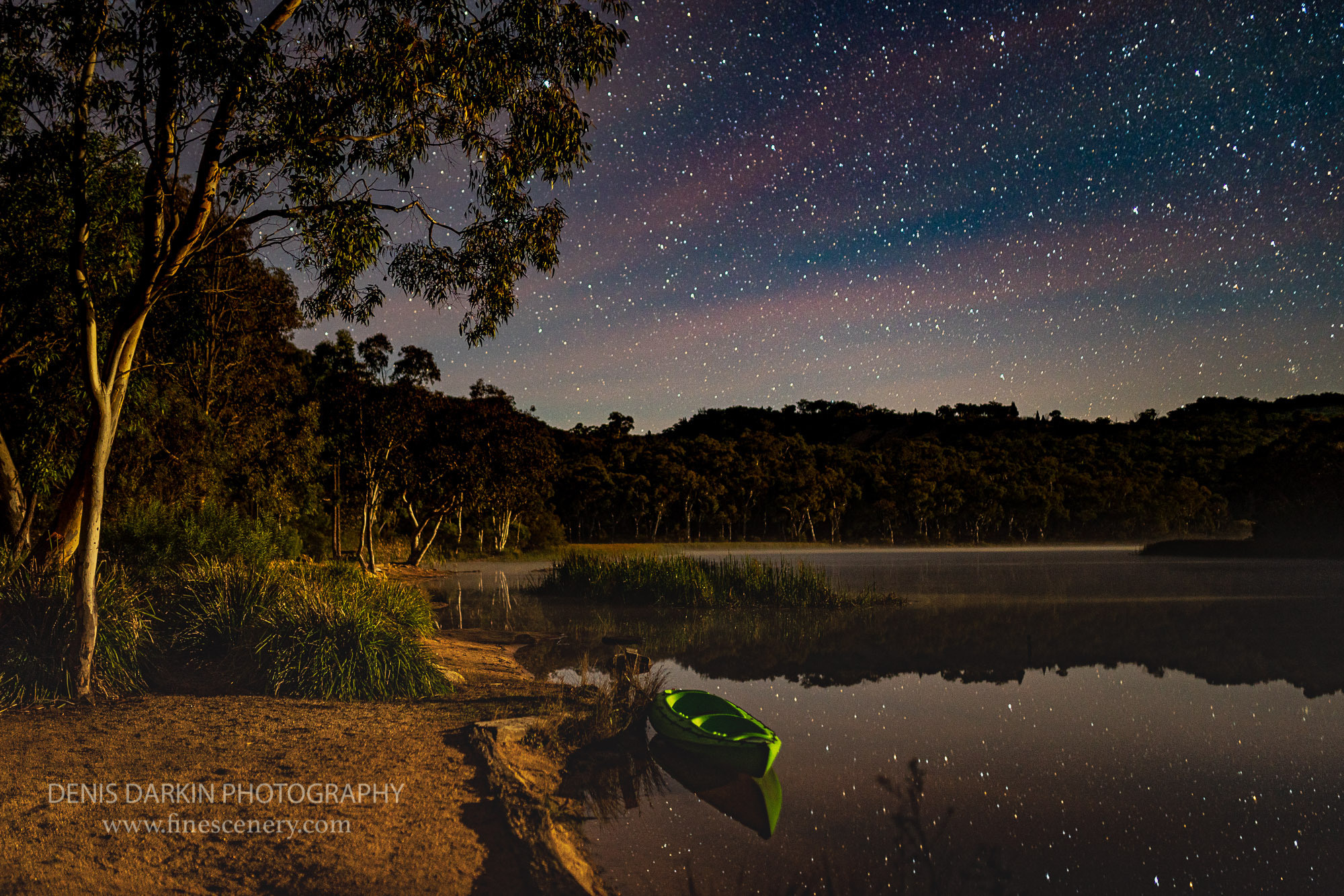 Kayak rests in the moonlight while the stars are reflected in the lakes still water, Dunns Swamp, Wollemi National Park, NSW.