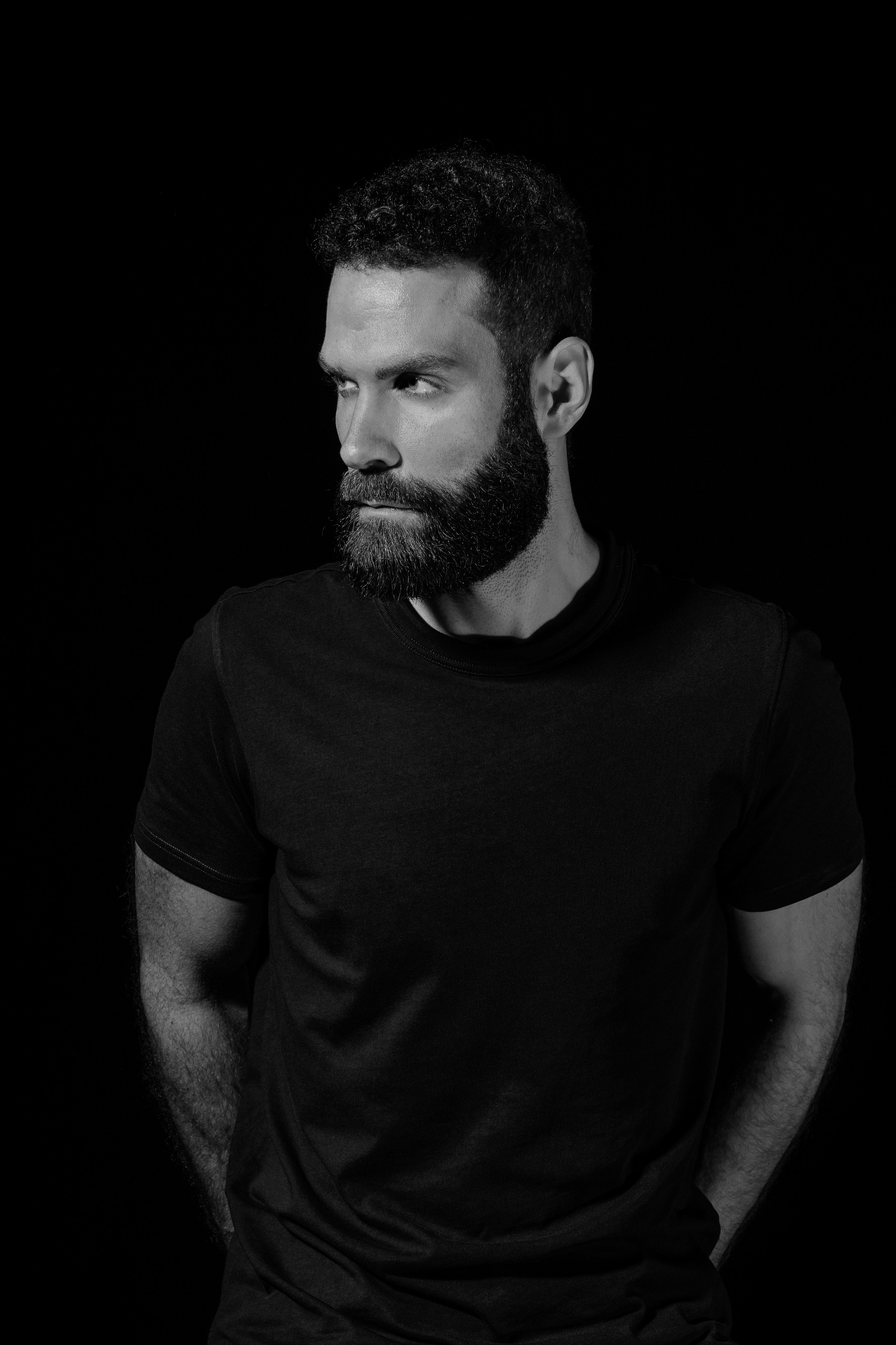 Schwarzweißes ausdrucksstarkes Männerporträt in dunklem Low-Key-Licht