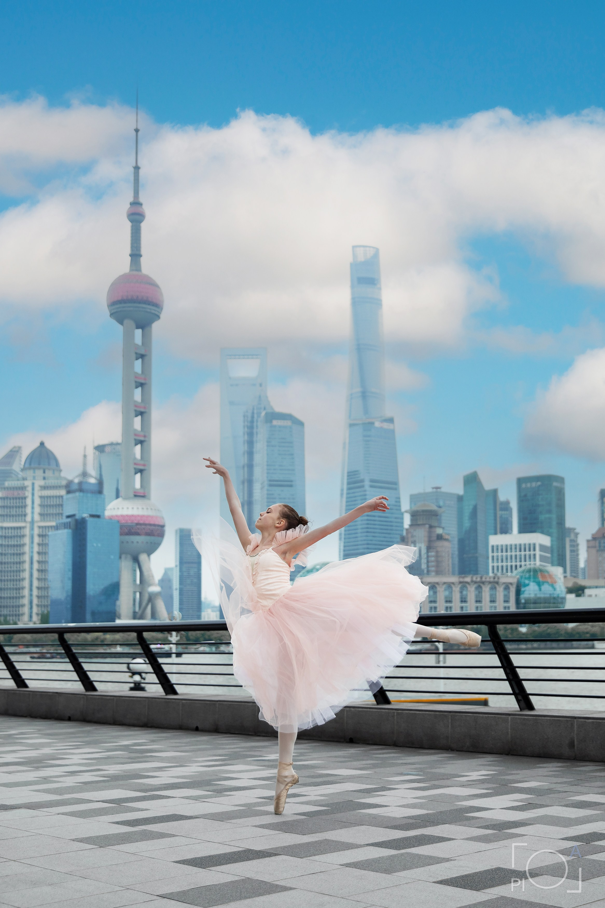 Фотосессия в Шанхае для девочки 11 лет. Маленькая балерина в розовом платье с пышной длинной пачкой, танцует на набережной в Шанхае с видом на Lujiazui