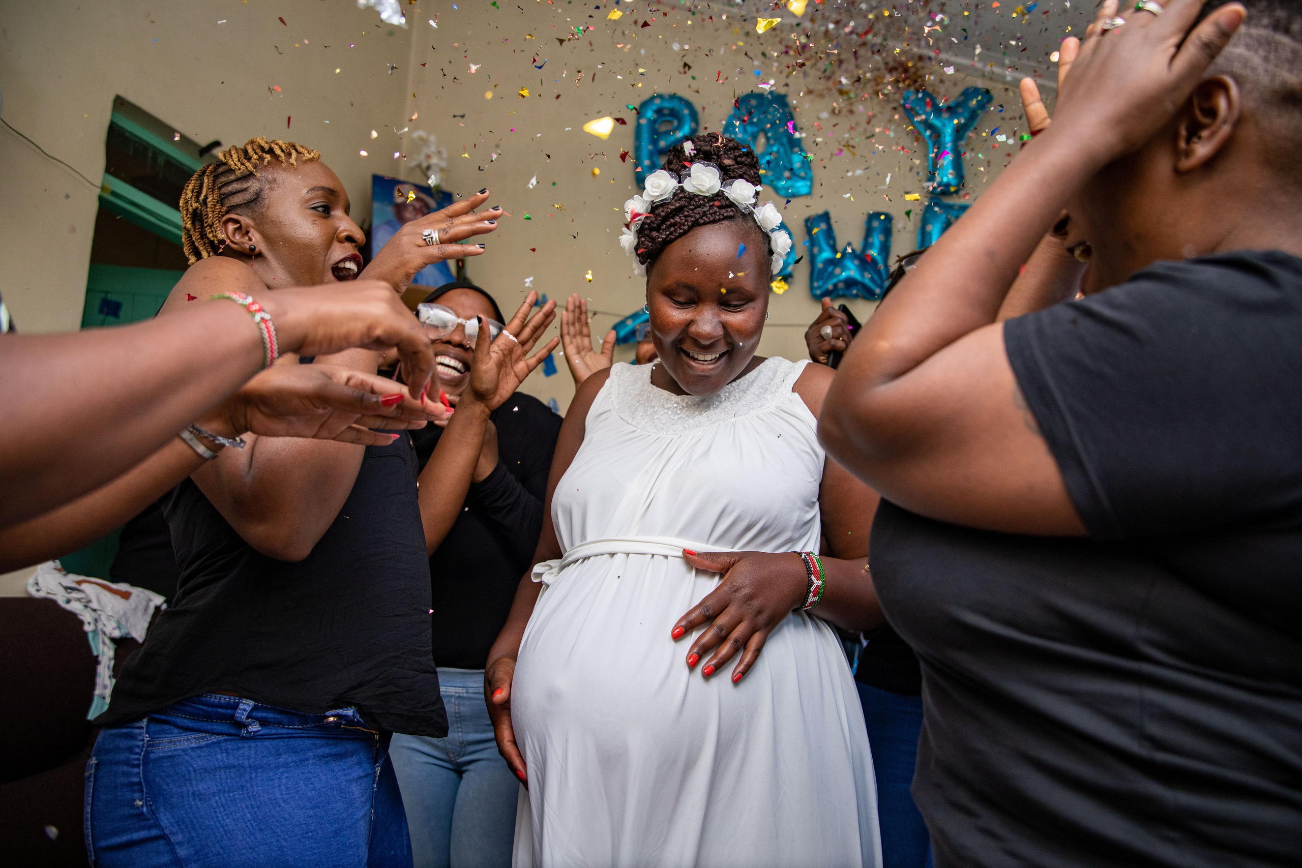 Expectant mother dancing with friends at a gender reveal in Nairobi