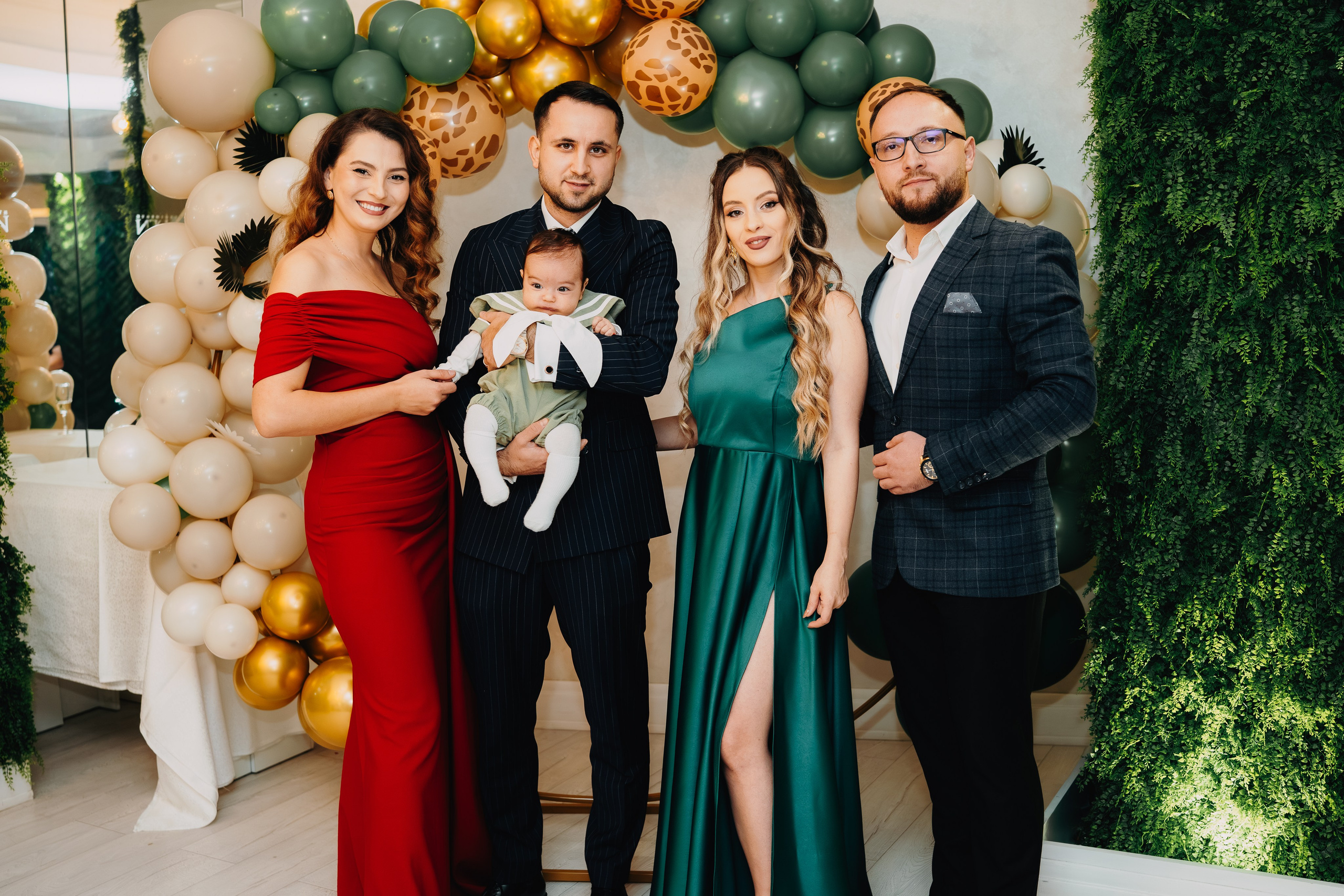 Poză completă de familie de la botezul lui Arthur Mihail la Restaurantul Monden din Bârlad. Părinții și nașii sunt uniți în jurul pruncului, ținându-l cu mândrie și bucurie. Imaginea finală care încheie povestea ceremonială și deschide cea a amintirilor comune.