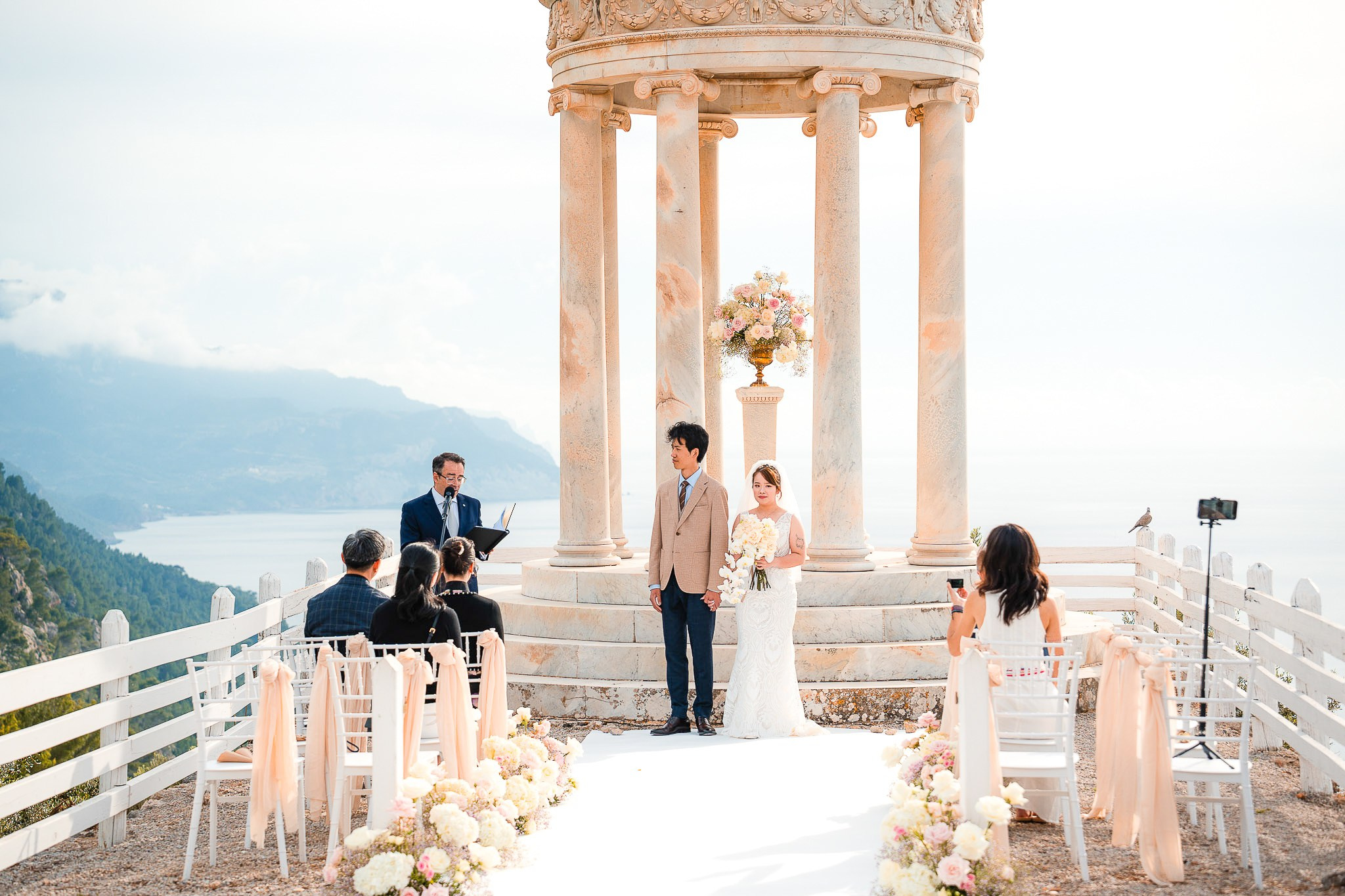 Wedding officiant reading the ceremony as bride and groom stand together at Son Marroig, Mallorca
