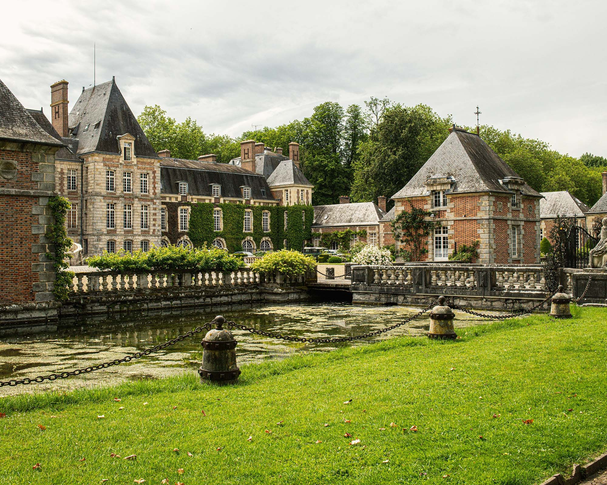 Historic courtyard and moat at Château de Courances in the French countryside